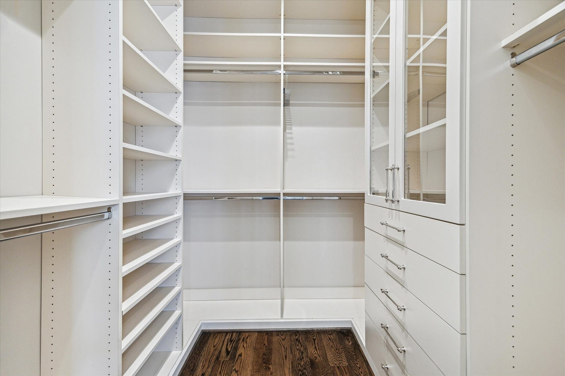 2413 Mimosa Drive, Houston, TX 77019 The second walk-in closet offers another fully built-out storage space rather than an overflow closet. Adjustable shelving, multiple hanging levels, drawers, and glass-front cabinetry make the dual-closet setup one of the suites most practical luxuries.