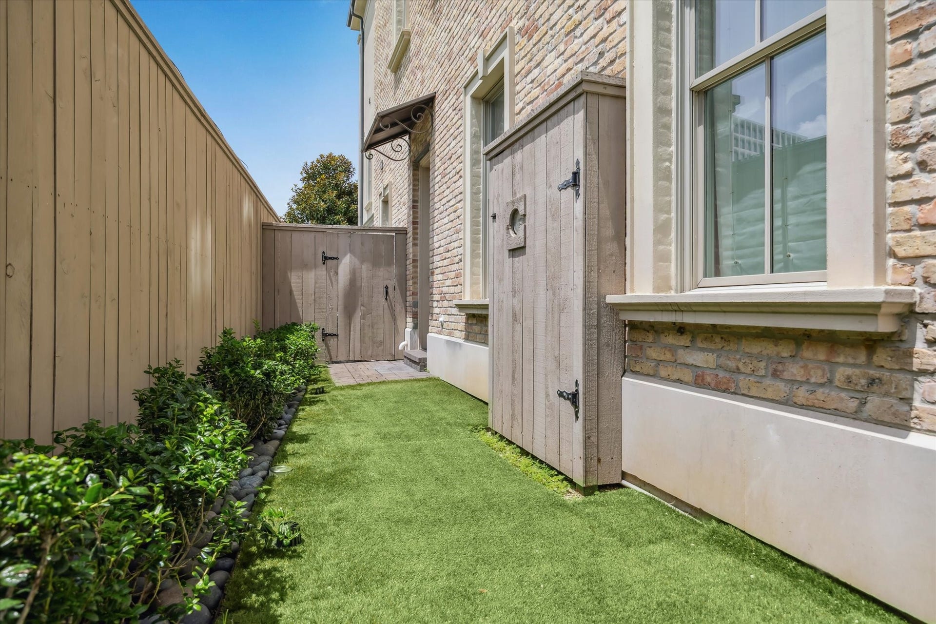 2413 Mimosa Drive, Houston, TX 77019 A tucked-away outdoor area along the side of the home provides usable private space without the upkeep of a traditional yard. Turf, established landscaping, and fencing create an easy spot for pets, a small seating area, or simply some additional outdoor breathing room.