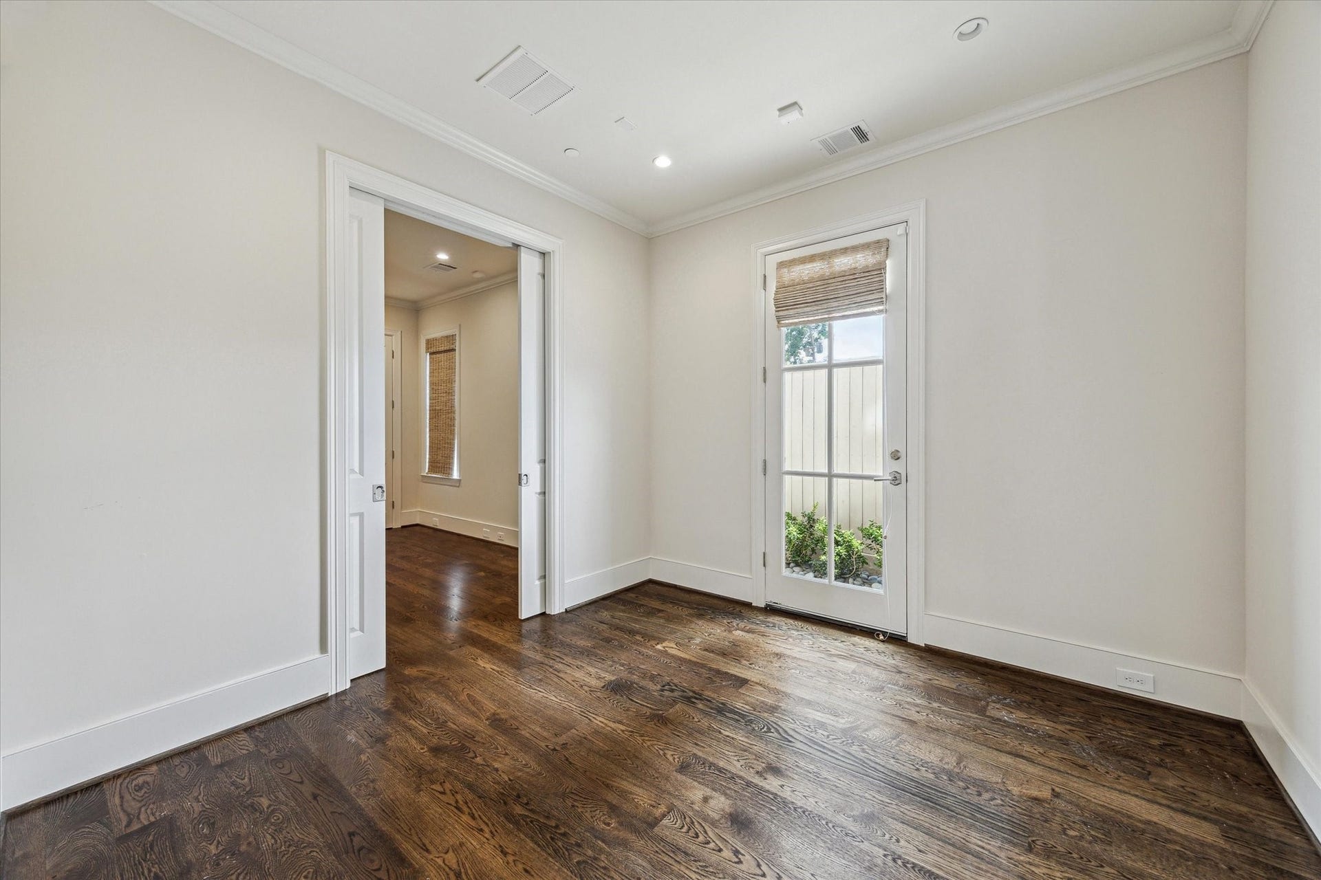 2413 Mimosa Drive, Houston, TX 77019 A glass-paned exterior door brings natural light into this flexible office or sitting room and creates a quiet connection outdoors. Pocket doors allow it to open to the adjoining space or close completely, making the pair especially adaptable for guests, work, or everyday living.