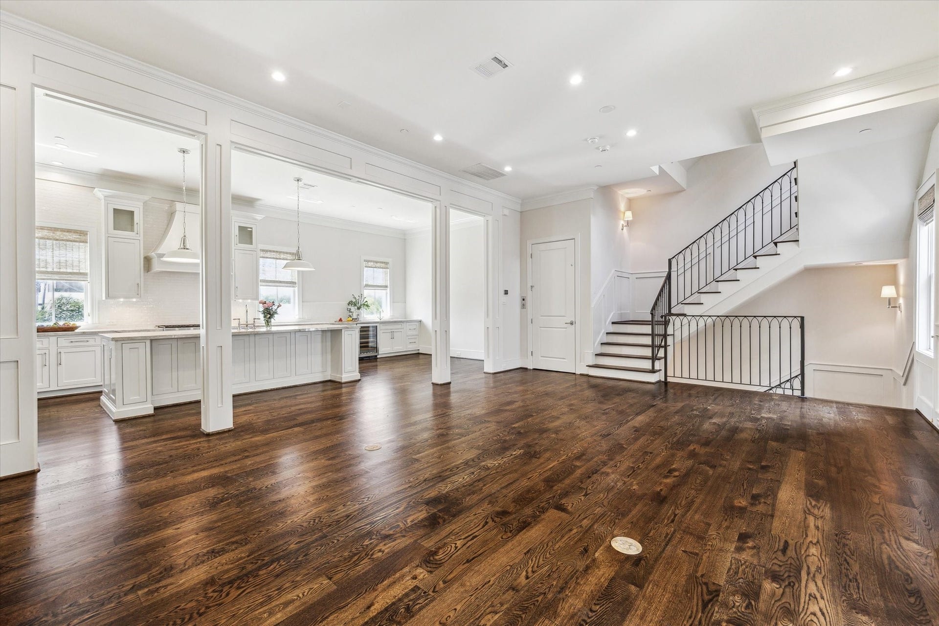 2413 Mimosa Drive, Houston, TX 77019 Oversized cased openings frame the kitchen while the staircase remains visible beyond, allowing the entire level to feel connected without reading as one undivided room.