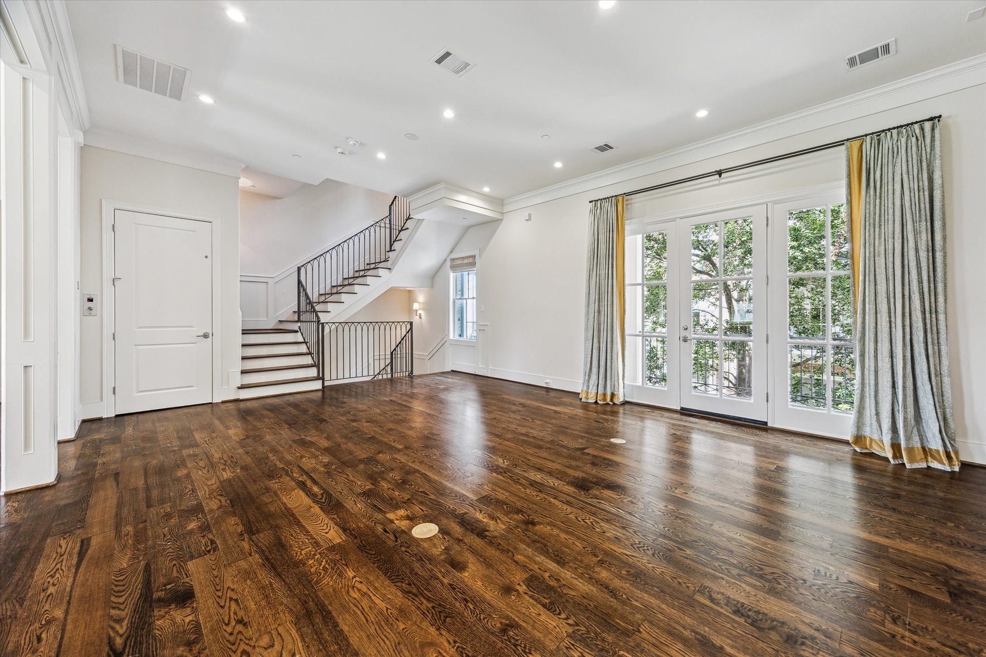2413 Mimosa Drive, Houston, TX 77019 A wall of French doors brings the trees almost into the room and gives the living space a leafy outlook unusual for an urban setting. Open stairs at the opposite end keep the architecture connected from one level to the next.