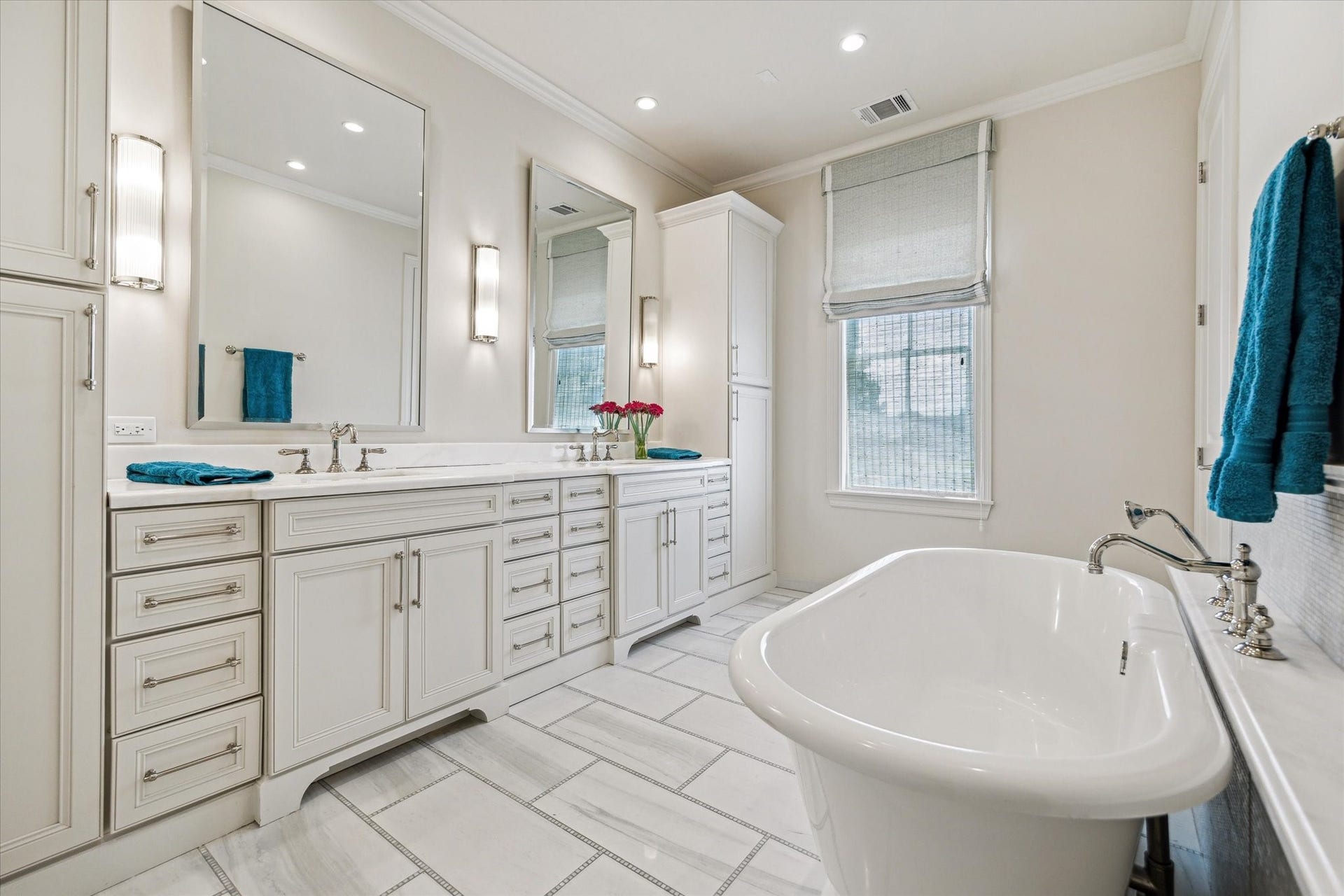 2413 Mimosa Drive, Houston, TX 77019 The primary bath is designed with both beauty and storage in mind. Dual sinks are set into an extended custom vanity with an impressive amount of cabinetry, while a freestanding soaking tub creates a natural focal point across the room.