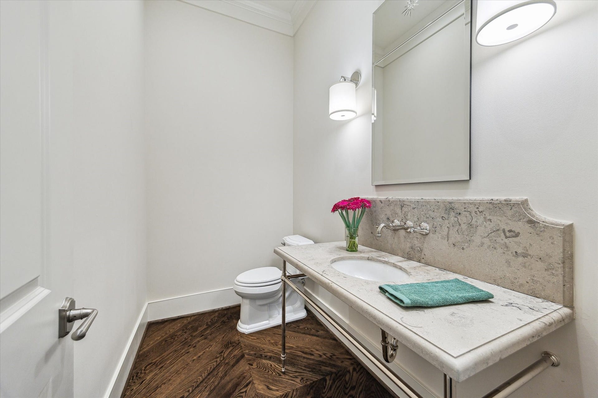 2413 Mimosa Drive, Houston, TX 77019 Just off the kitchen, the powder room carries the homes understated finishes through with a stone vanity, wall-mounted faucet, hardwood floors, and clean, tailored detailing.