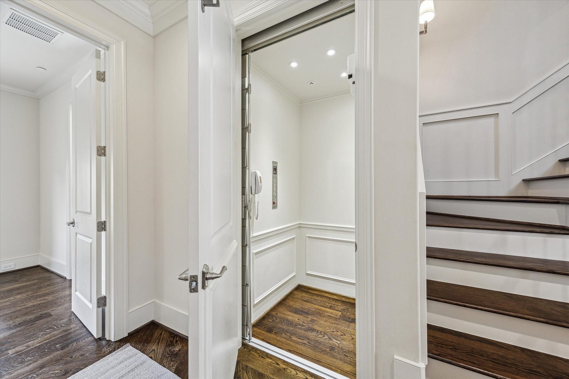 2413 Mimosa Drive, Houston, TX 77019 One of the homes most practical luxuries is tucked discreetly beside the staircase: a private elevator connecting every floor. Hardwood flooring and paneled walls carry the homes finishes inside, making it feel like an intentional part of the architecture rather than an afterthought.