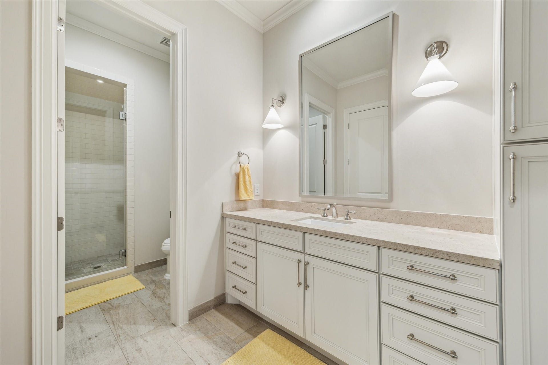 2413 Mimosa Drive, Houston, TX 77019 The fourth-floor guest suite includes a beautifully finished full bath with an extended vanity, generous drawer and cabinet storage, stone counters, and a glass-enclosed tiled shower.