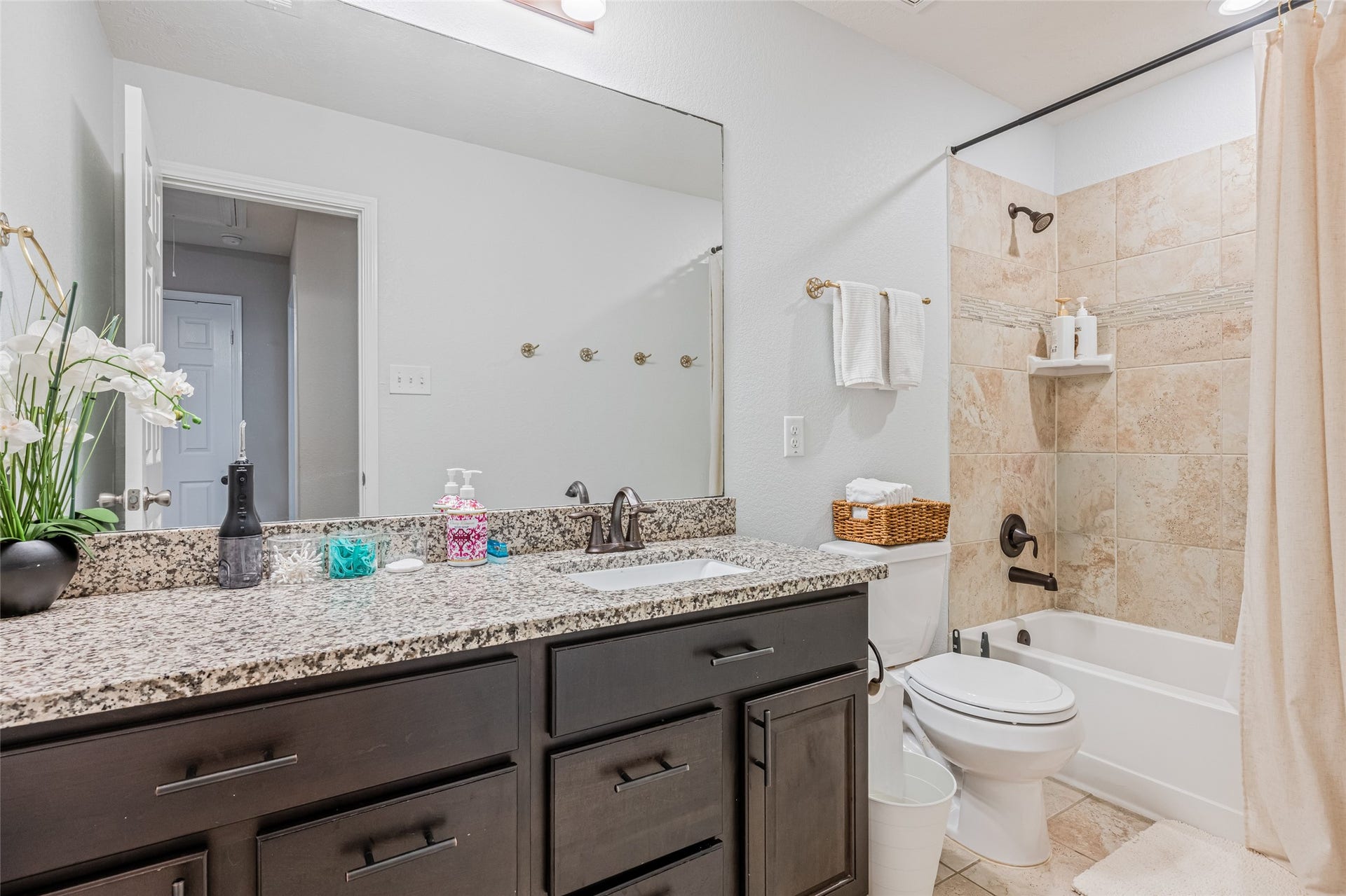 3806 Belmore Lane, Pearland, TX 77584 Start and end your day in this well-appointed full bathroom featuring a granite-topped vanity and tiled tub/shower surround.