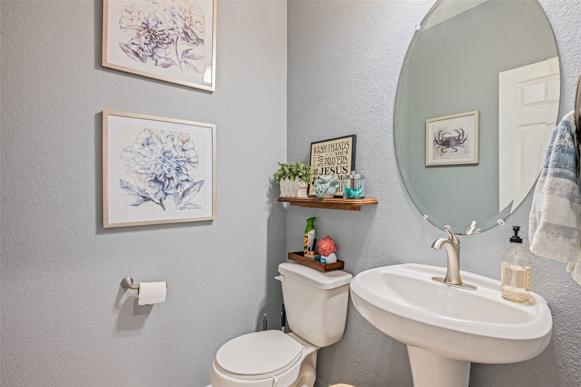 3806 Belmore Lane, Pearland, TX 77584 Guests have a convenient powder room on the main level, complete with a pedestal sink, oval mirror, and space for decorative touches.