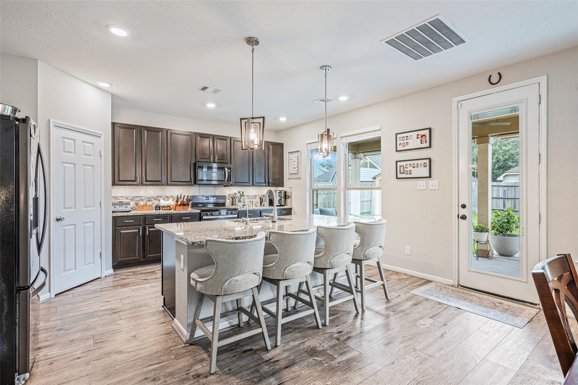 3806 Belmore Lane, Pearland, TX 77584 Morning coffee and casual meals have a natural gathering spot at your oversized island, with seating for four and easy access to the covered patio just steps away.