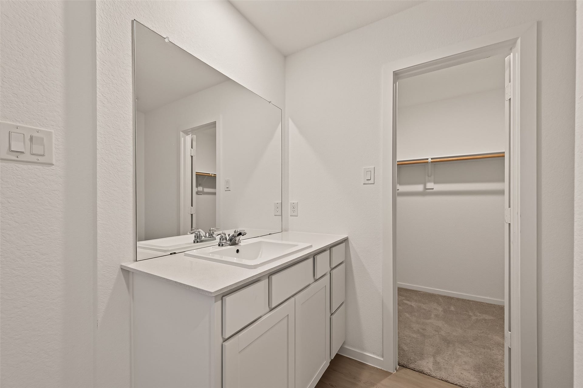 7814 Lavender Jade Drive, Rosharon, TX 77583 large sink with corian counter top large mirror and the entrance to the walk in closet