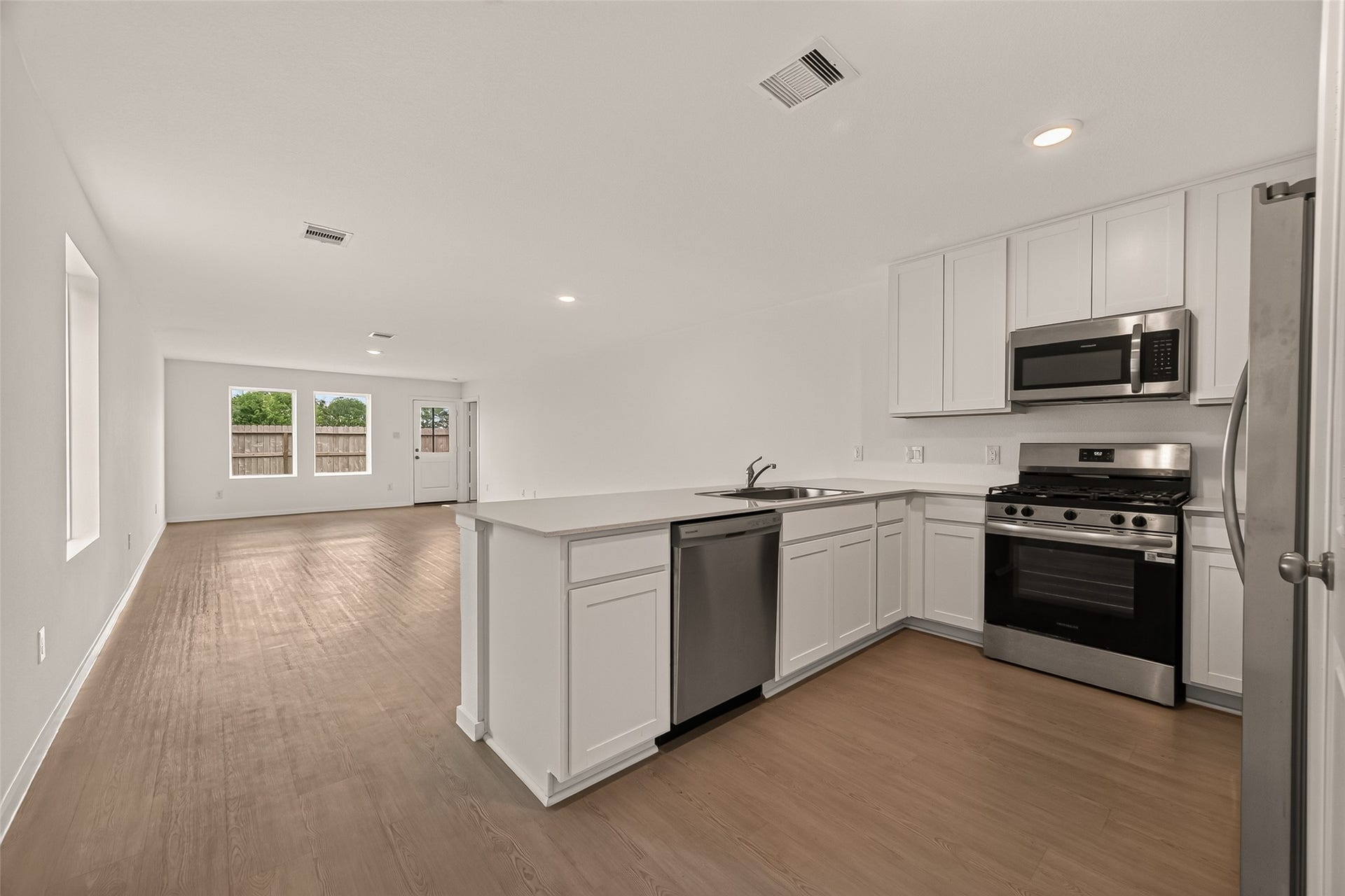 7814 Lavender Jade Drive, Rosharon, TX 77583 Spacious kitchen featuring an abundance of cabinet storage and a versatile island that doubles as a convenient breakfast bar. The open floor plan creates a seamless flow, making this home ideal for entertaining guests.