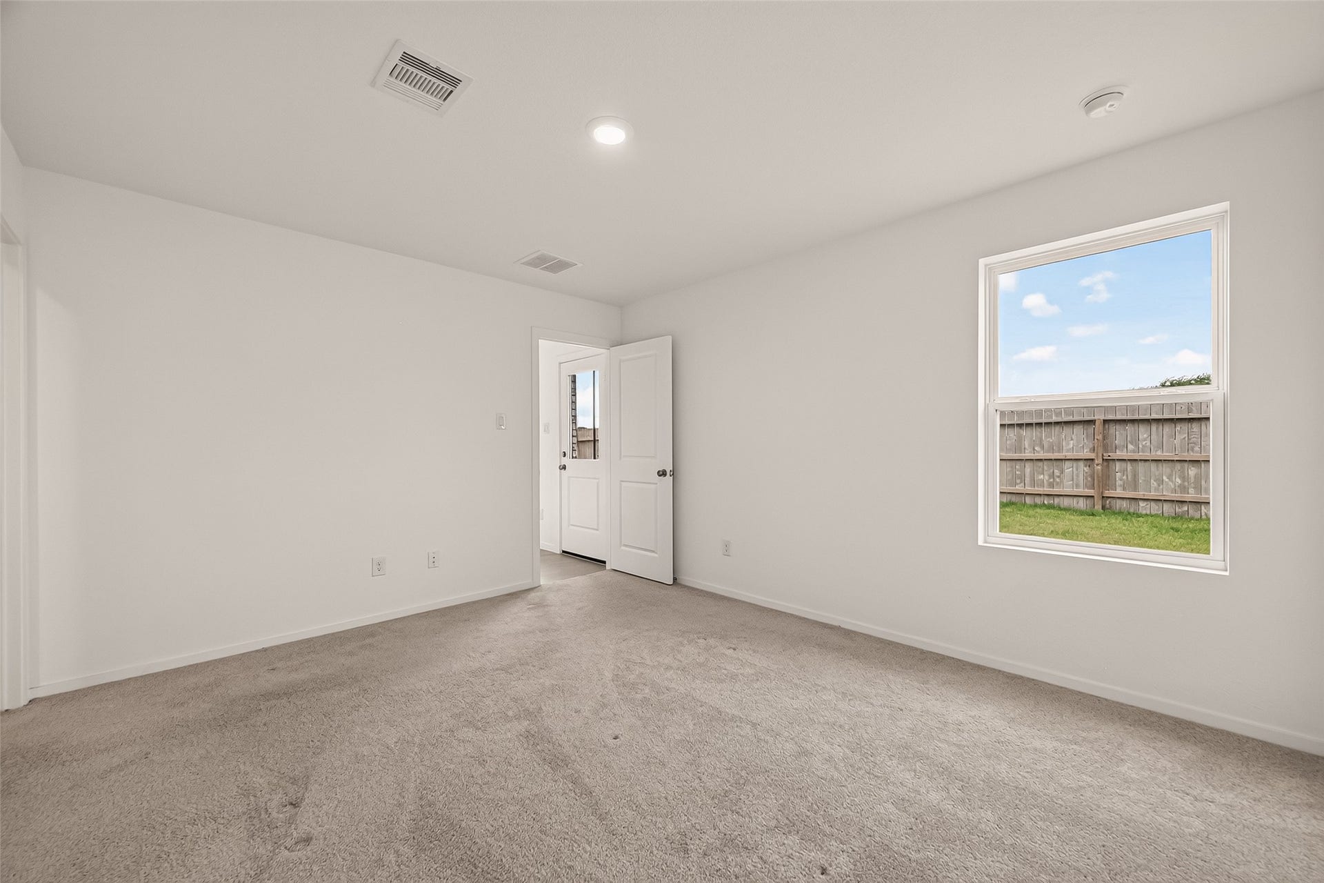 7814 Lavender Jade Drive, Rosharon, TX 77583 This image highlights the home's primary entrance, situated directly opposite the living room's rear entry, and showcases a large window that invites abundant natural light into the space.