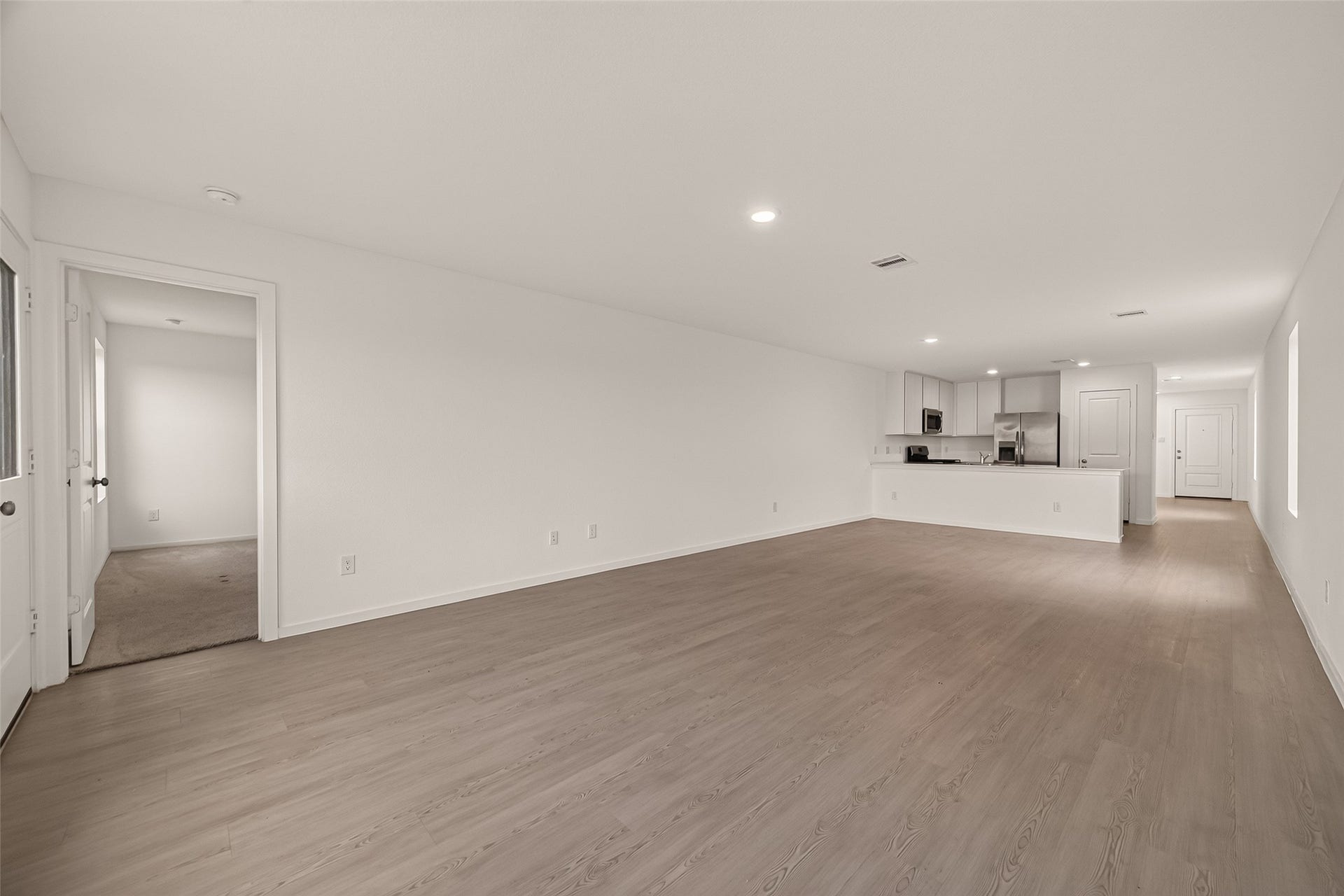 7814 Lavender Jade Drive, Rosharon, TX 77583 Spacious, light-filled open concept living and dining area featuring a versatile floor plan. The seamless flow leads to a private entry for the primary suite, perfectly situated within this split floor plan layout for maximum privacy.
