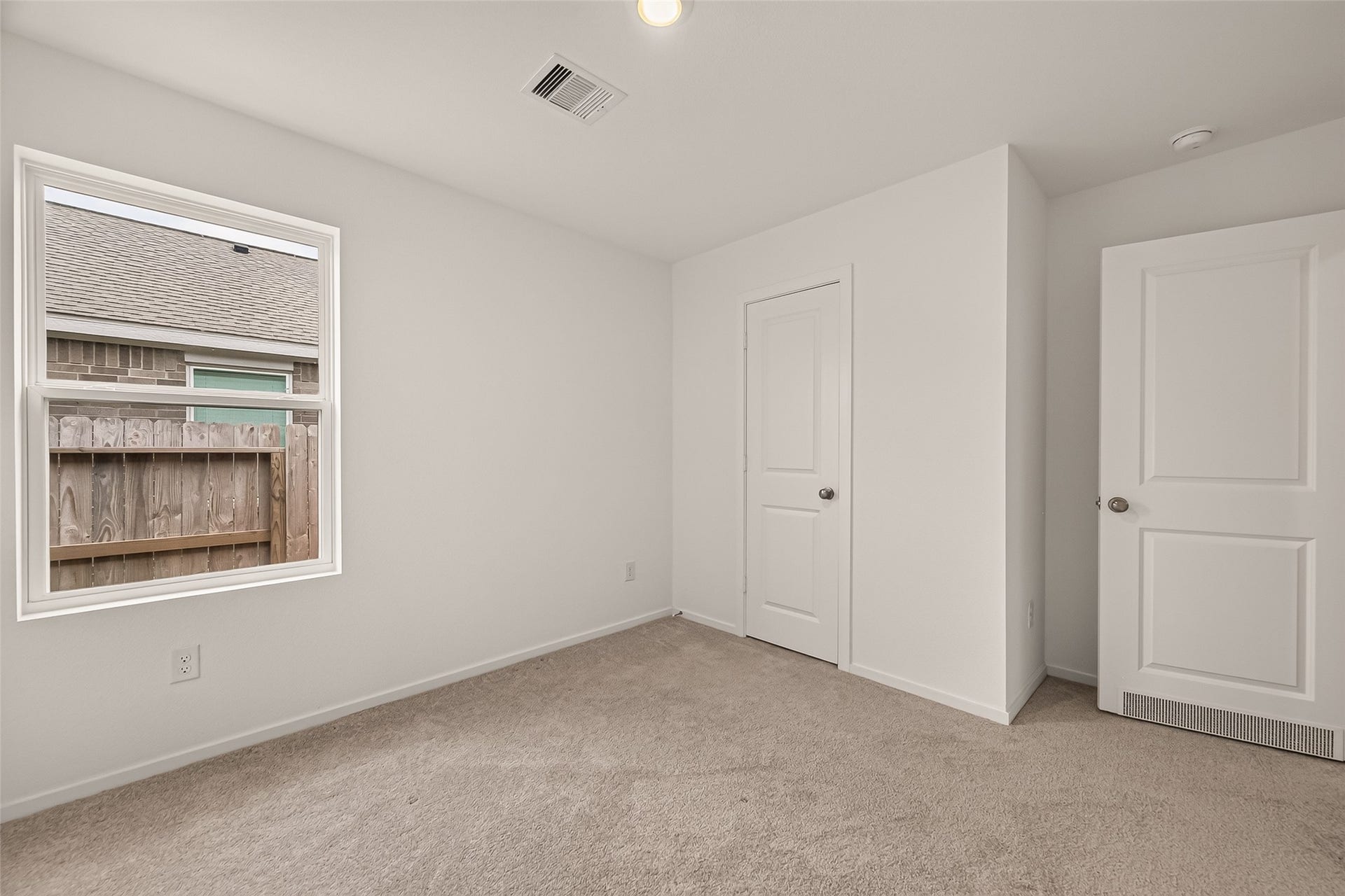 7814 Lavender Jade Drive, Rosharon, TX 77583 view 1 of 3rd secondary bedroom featuring a large window that invites abundant natural light and pristine, like-new carpeting throughout.