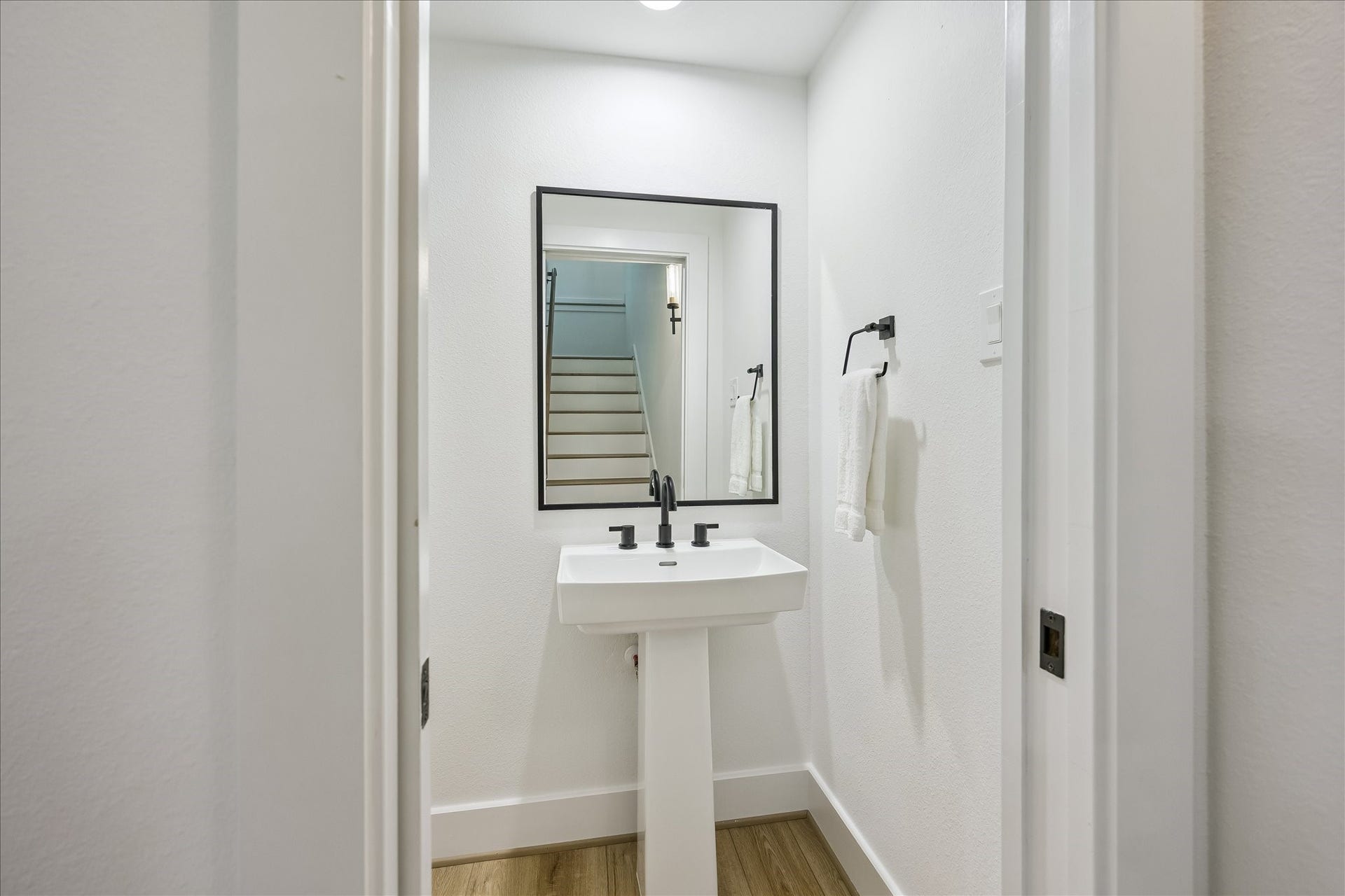 A conveniently located powder bath is tucked discreetly off the stair landing.