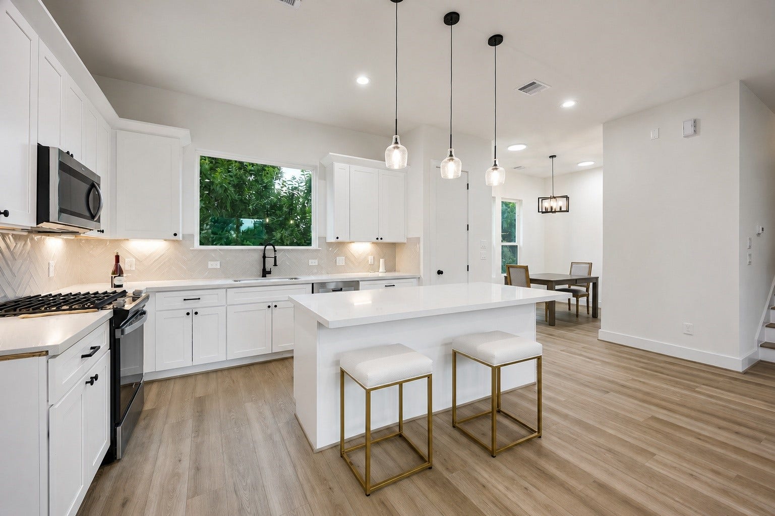 The beautiful kitchen features a gas range, generous island seating, and an abundance of natural light.
