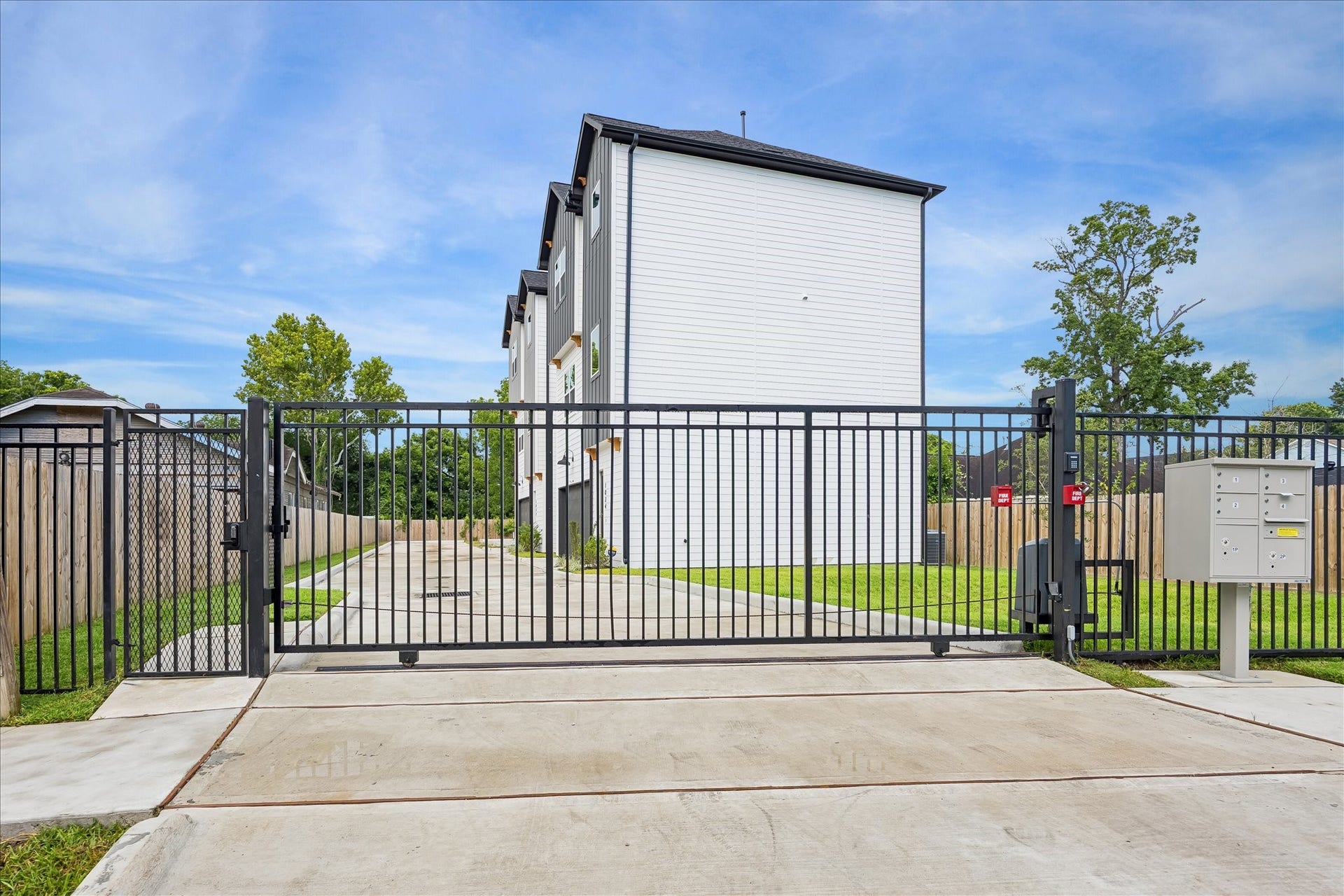 The private driveway is secured by a motorized entry gate, with a separate pedestrian gate providing convenient access for guests.