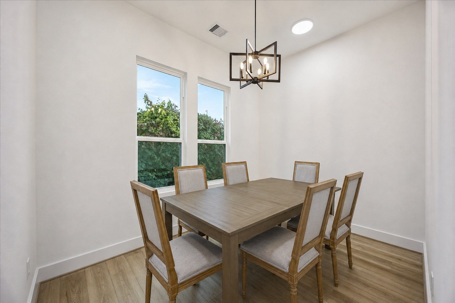 Just beyond the kitchen, the dining area comfortably accommodates seating for eight, making it ideal for both everyday meals and entertaining.