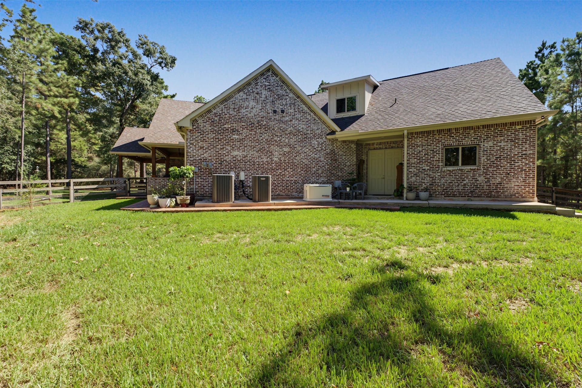501 Corsair Court, Montgomery, TX 77316 From the side of the home behind the garage, there is access to the oversized garage with workshop.