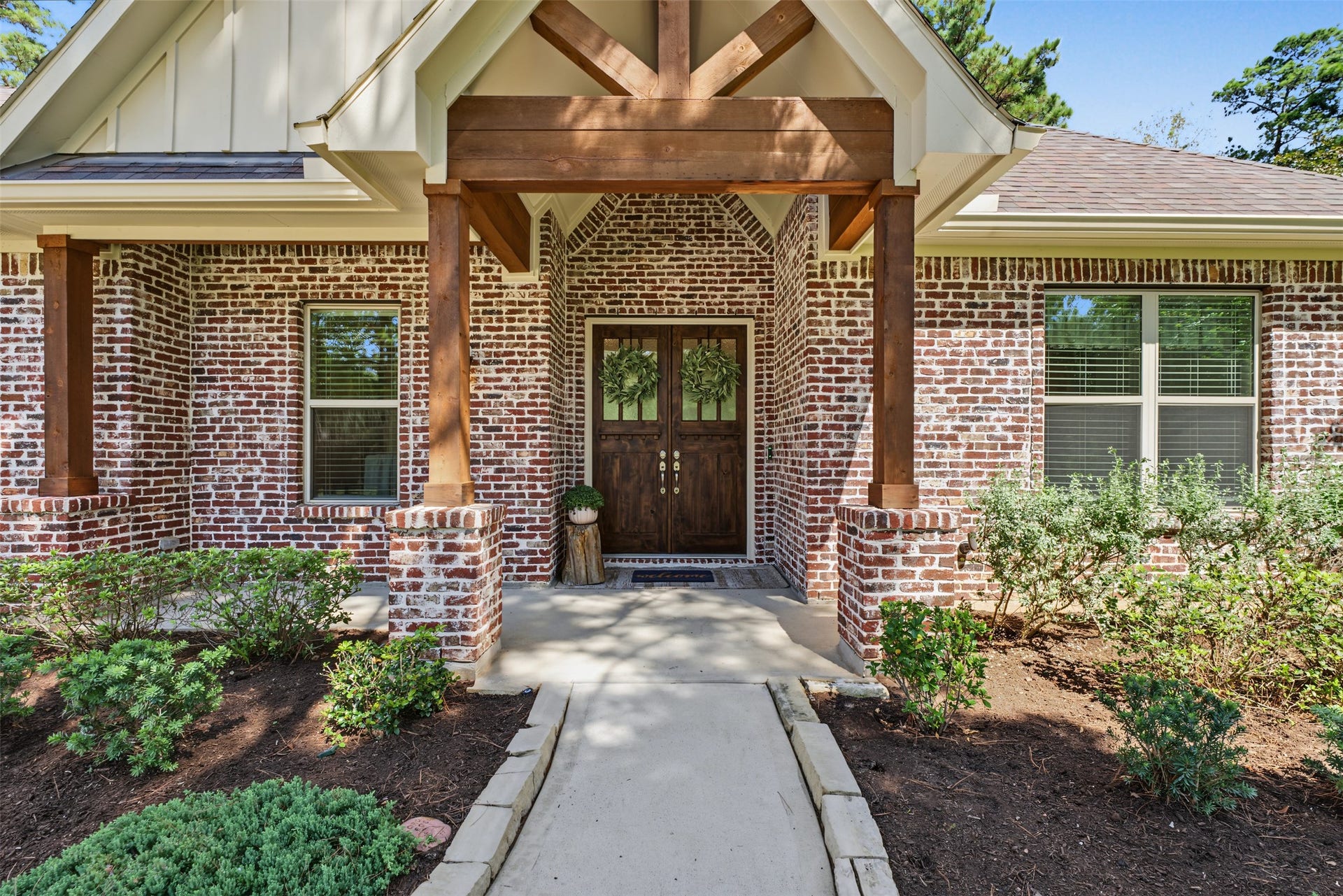 501 Corsair Court, Montgomery, TX 77316 Exterior features custom blended antique brick whitewash mortar and cedar wrapped beams.