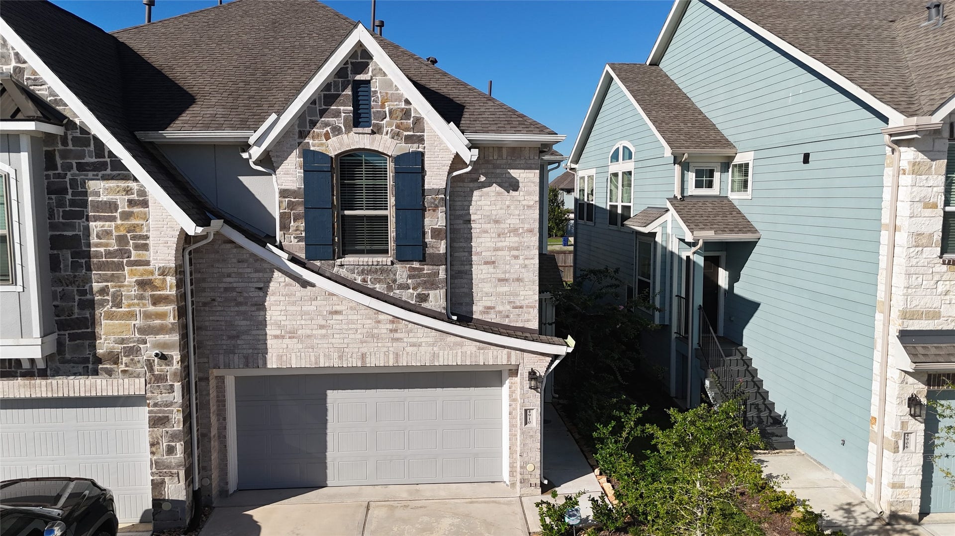 4910 Anders Lane, Manvel, TX 77583 Front exterior of the two-story townhome featuring a brick-and-stone faade, private driveway, and attached two-car garage.