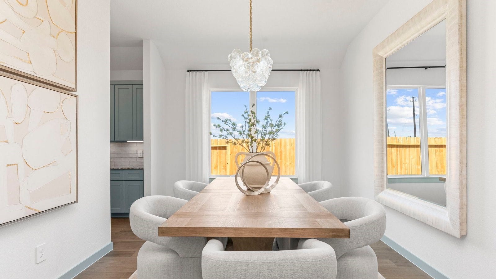 Spacious dining area with vinyl wood flooring, large window and a tall ceiling.