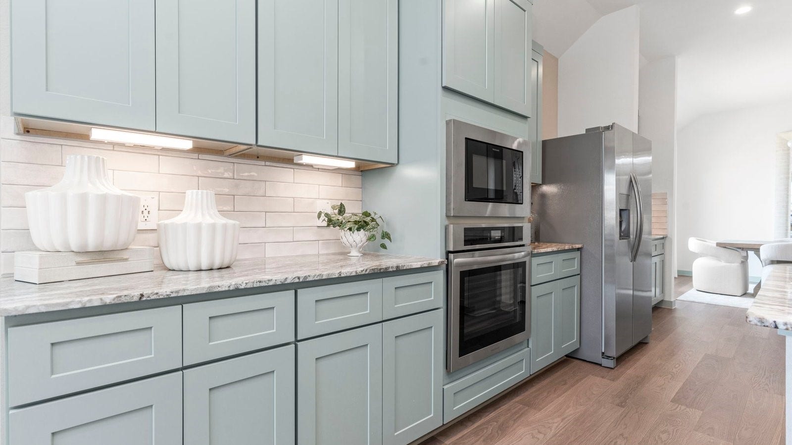 Kitchen adorned with painted cabinets seamlessly integrated into an open dining area layout.