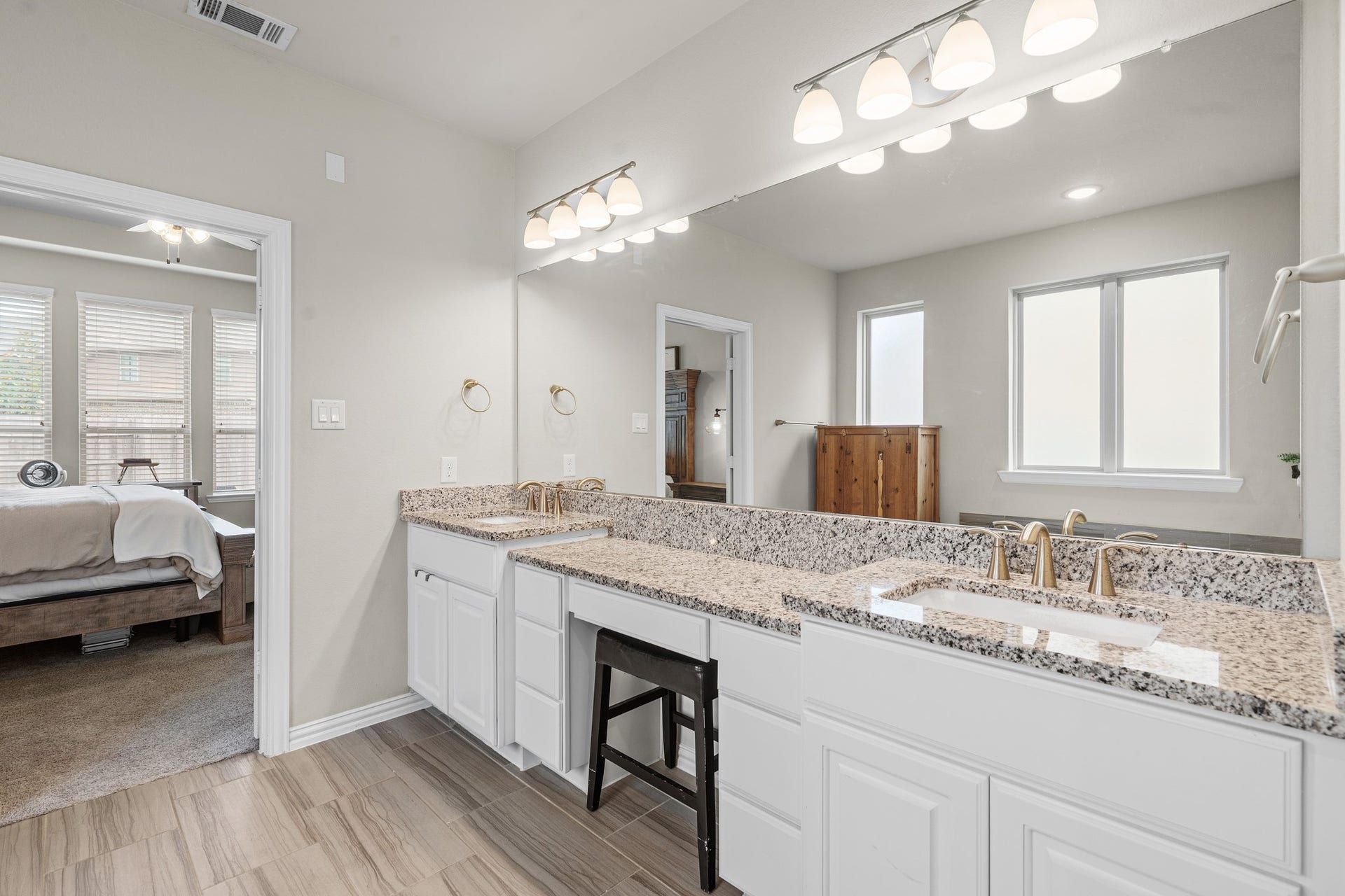 Focused on the main vanity space, this view highlights the extensive length of the polished granite counters and the convenience of a built-in vanity.