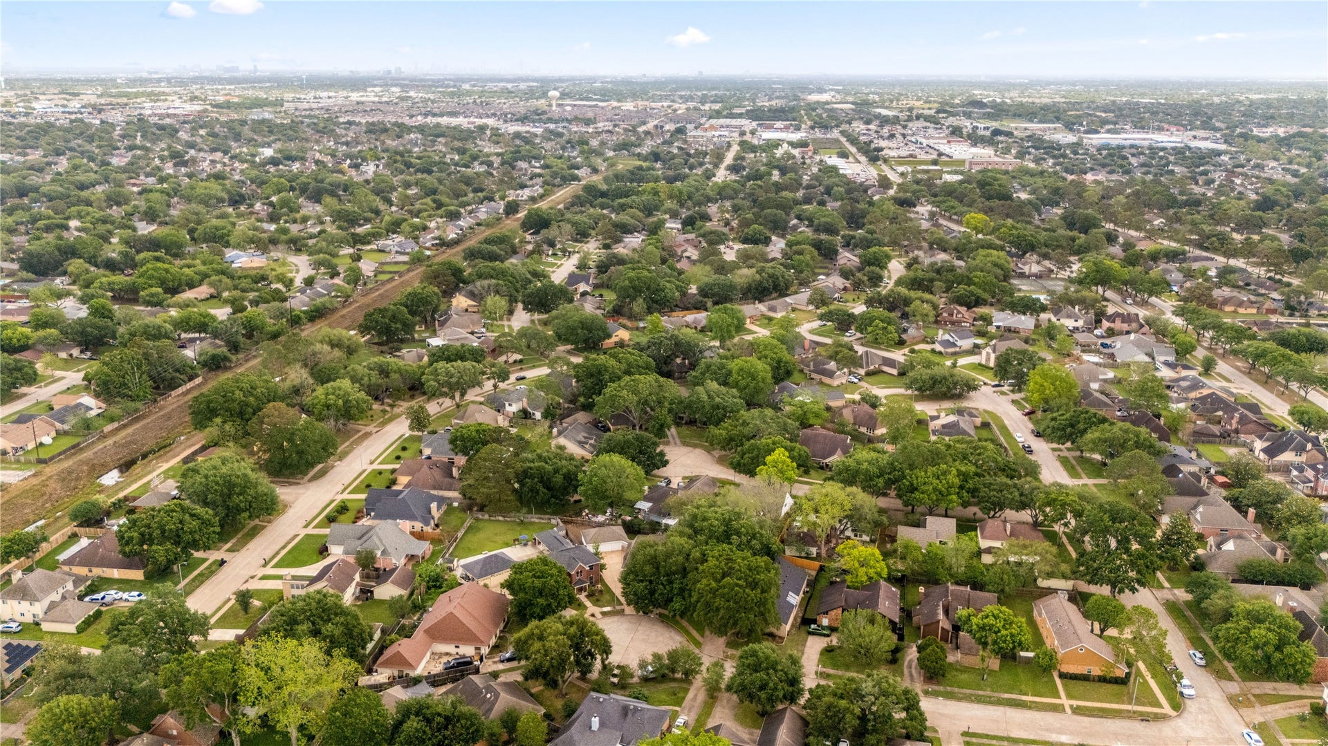 8007 Suspiro Drive, Houston, TX 77083 This impressive aerial perspective showcases the neighborhood's meticulous layout, featuring quiet streets, lush green spaces, and a true sense of suburban serenity. Enjoy the benefit of being part of a thriving area with easy access to local amenities and major thoroughfares, all while maintaining the peaceful atmosphere of a residential retreat.