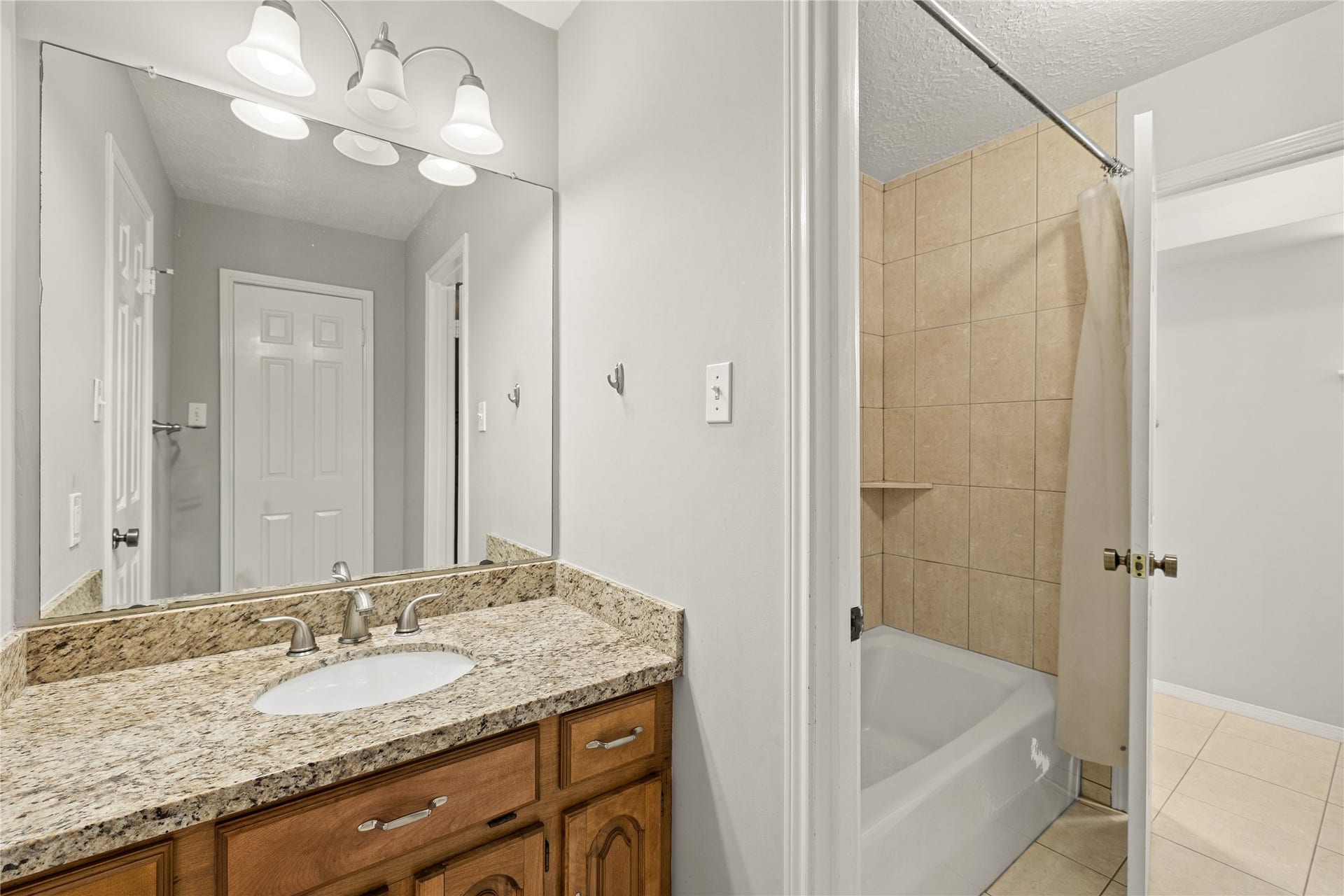 8007 Suspiro Drive, Houston, TX 77083 Secondary bathroom features a tub/shower combination with tile surround and tile flooring.