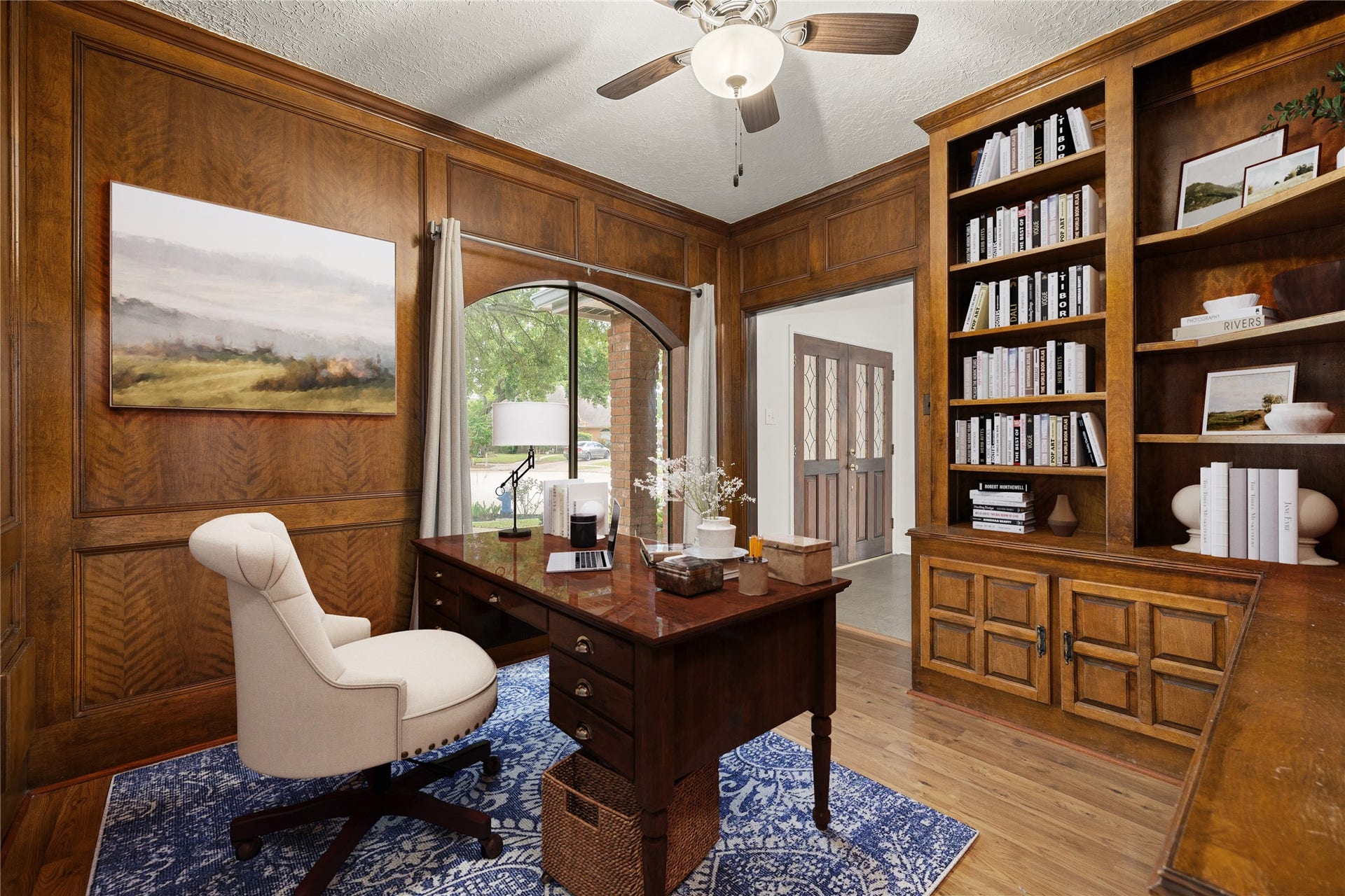 8007 Suspiro Drive, Houston, TX 77083 Quietly nestled in front of the home is the handsome home office! Featuring wood flooring, high ceilings, large arched window, ceiling fan, custom paint, and a large built-in bookcase! *Virtually Staged