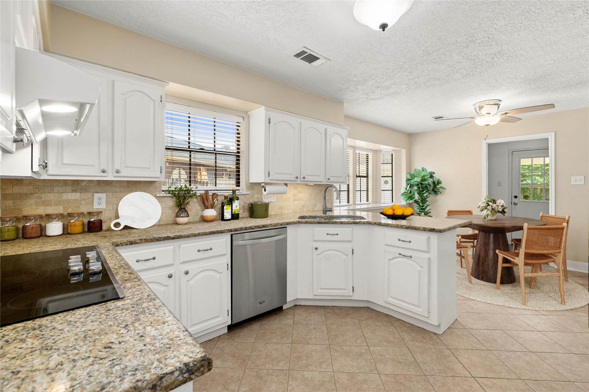 8007 Suspiro Drive, Houston, TX 77083 This bright and functional kitchen is a chefs delight, combining timeless style with a layout designed for effortless entertaining. Crisp white cabinetry is beautifully complemented by granite countertops and a stone-tile backsplash, creating an inviting space that flows seamlessly into the sun-lit breakfast nook. *Virtually Staged