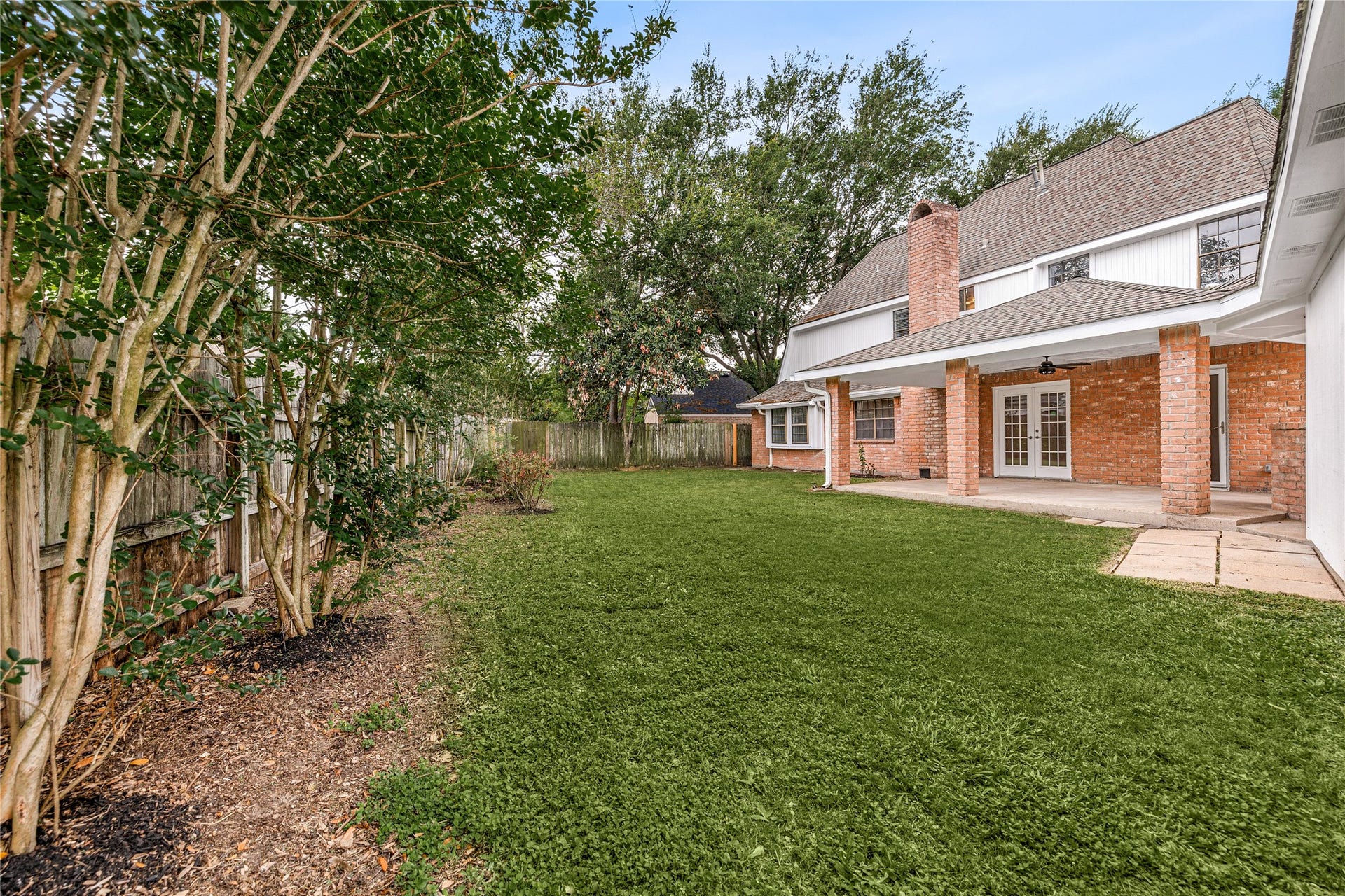 8007 Suspiro Drive, Houston, TX 77083 This expansive backyard is a true hidden gem, offering a peaceful and private retreat with plenty of room to roam. Framed by mature trees that provide natural shade and character, the level green lawn is a versatile space for gardening, outdoor play, or your future backyard projects.