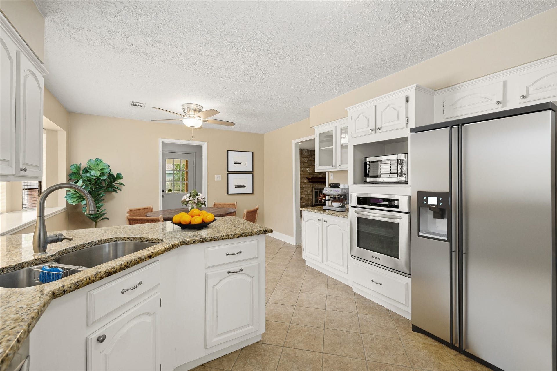 8007 Suspiro Drive, Houston, TX 77083 This expanded view showcases a highly functional gourmet layout, featuring a dedicated wall of appliances and a convenient coffee station. The kitchen's open design ensures the chef is always part of the conversation, with clear sightlines into both the breakfast nook and the main living areas. *Virtually Staged