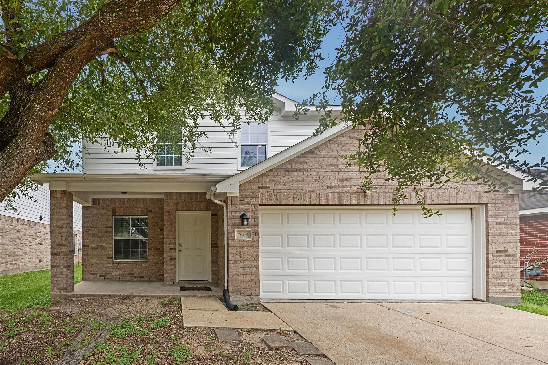 20815 Dewberry Creek Lane, Katy, TX 77449 This charming two-story home features a brick facade with a spacious two-car garage. A mature tree provides shade to the entrance, which includes a cozy front porch. The well-maintained exterior offers great curb appeal in a quiet neighborhood.