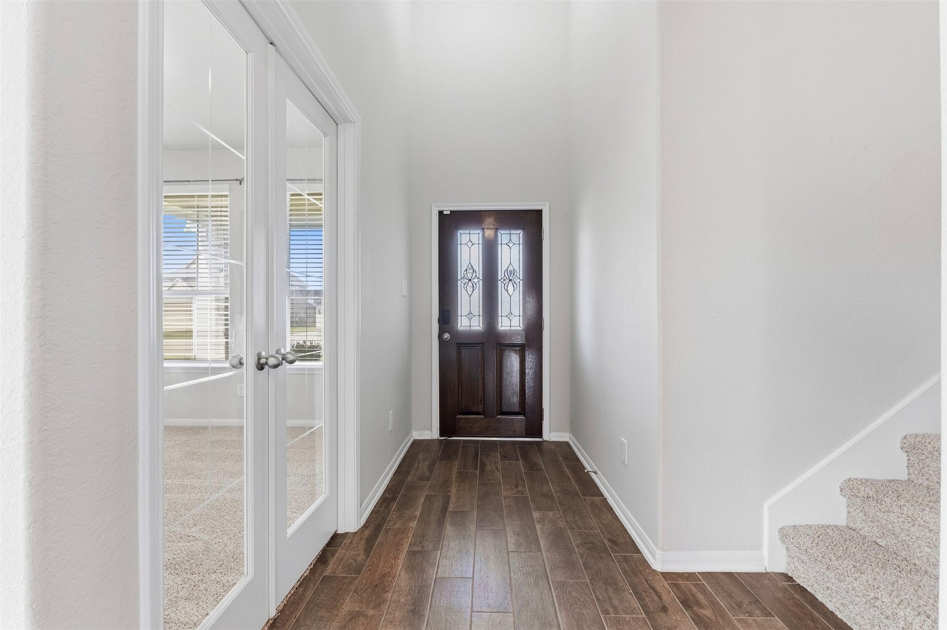 Entry way with a tucked away staircase behind the kitchen.