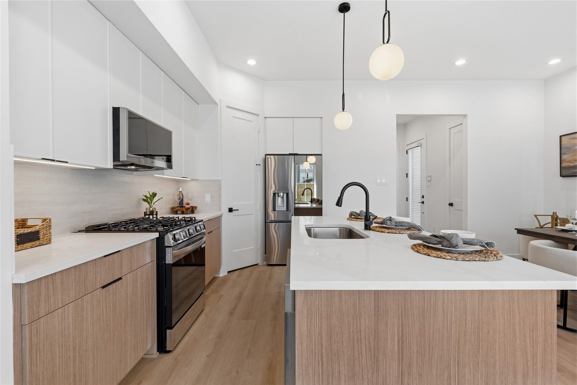 4610 Gunter Street, Houston, TX 77020 A large island with a white quartz contertops serves as the rooms anchor. Matte black fixtures and integrated stainless steel appliances provide a modern, high-contrast finish.