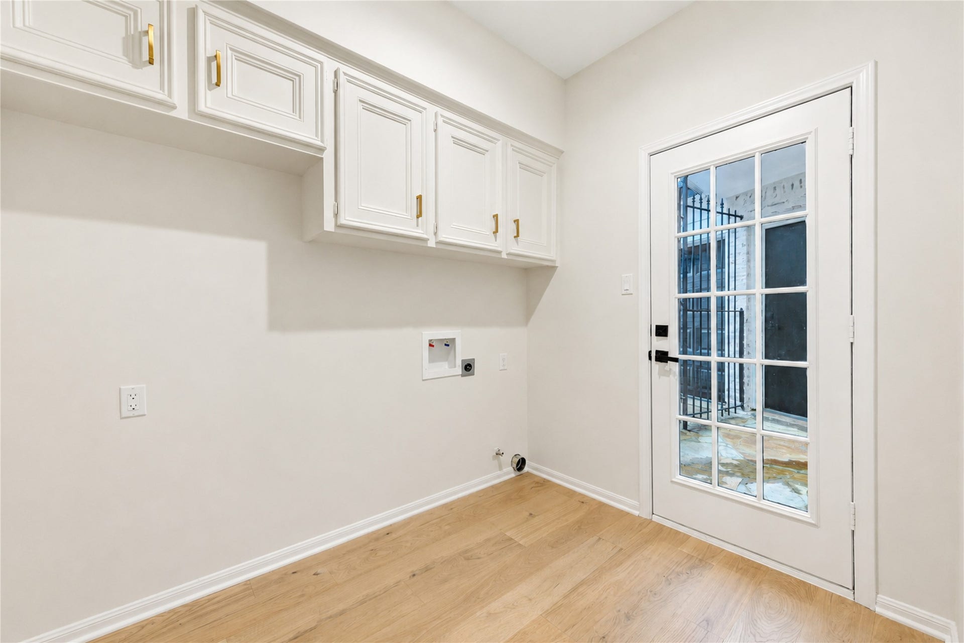 Convenient first-floor laundry room offers generous built-in cabinetry and workspace to keep everyday essentials organized, creating a bright, functional space that makes laundry day and household routines feel a little easier.