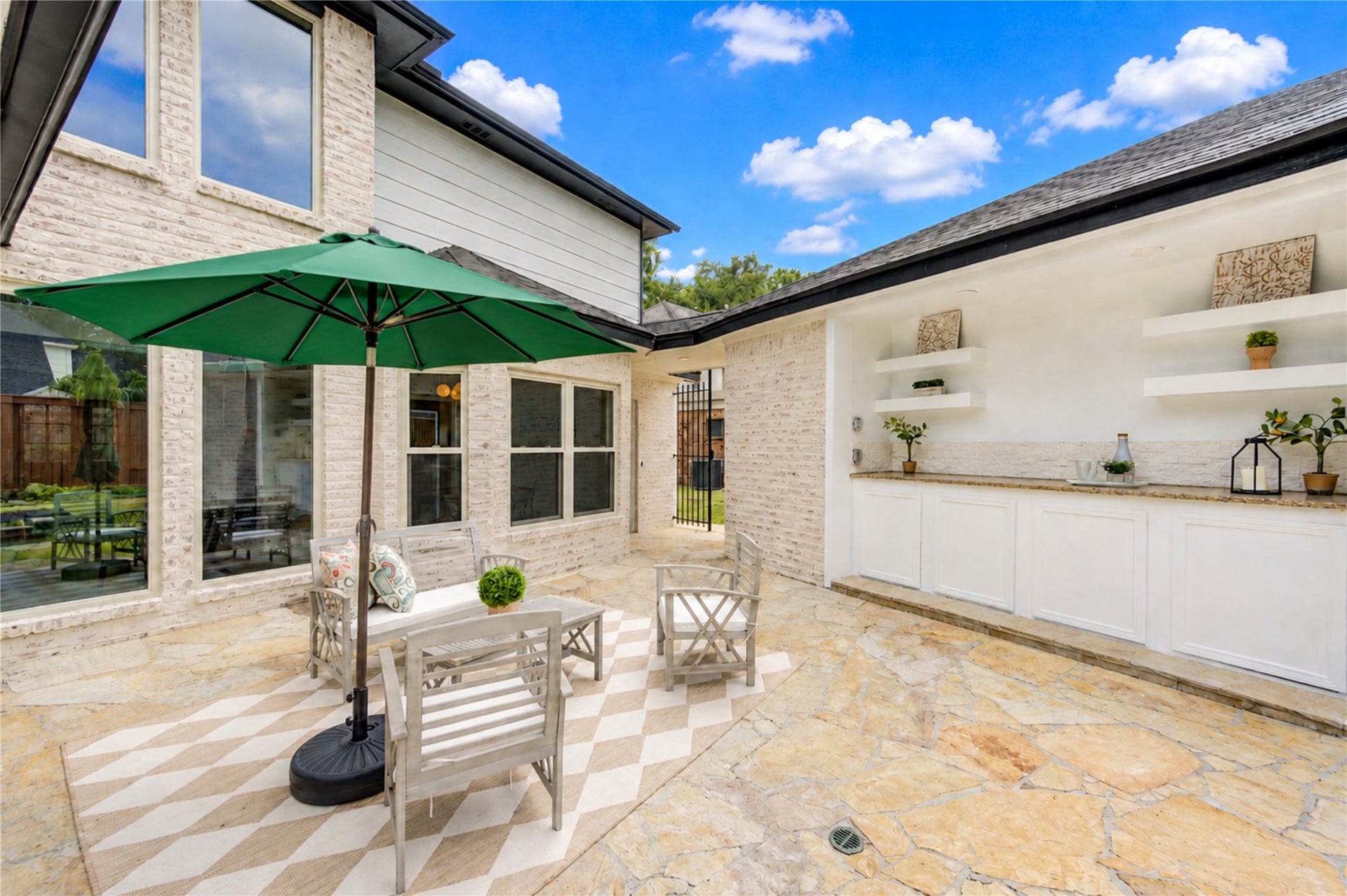 Expansive courtyard-style patio creates a wonderful extension of the homes living space, with generous room for outdoor seating, dining and entertaining. A built-in serving area with cabinetry and counter space makes it easy to host weekend gatherings, enjoy casual meals outdoors or relax with morning coffee before heading to the pool