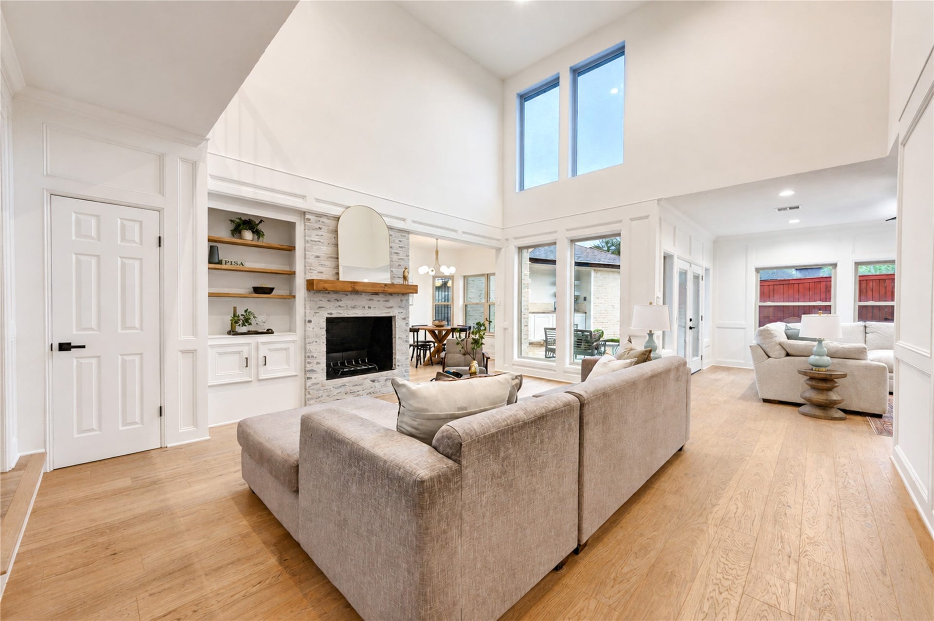 Formal living room and den share the same level, creating distinct yet connected spaces for relaxing and entertaining, highlighted by a striking German schmear fireplace and warm French Oak floors.