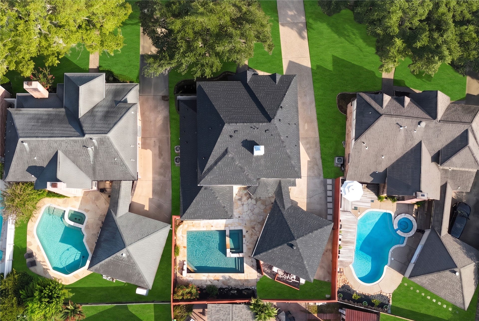 Birds-eye aerial view showcases the homes setting among mature trees and neighboring residences, with the sparkling backyard pool creating a private outdoor retreat for sunny afternoons, weekend gatherings and relaxed days at home.