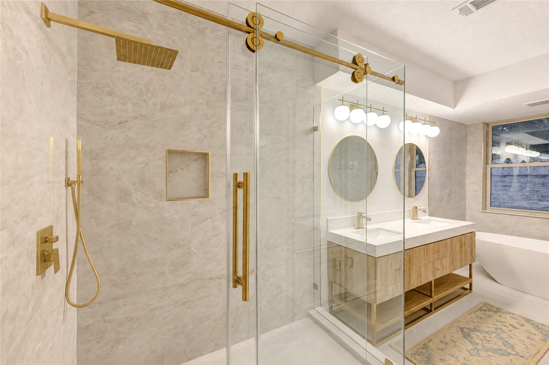Expansive walk-in shower creates a luxurious spa-like experience with a frameless glass door, beautiful tilework and stylish fixturesan elegant complement to the thoughtfully renovated primary ensuite.