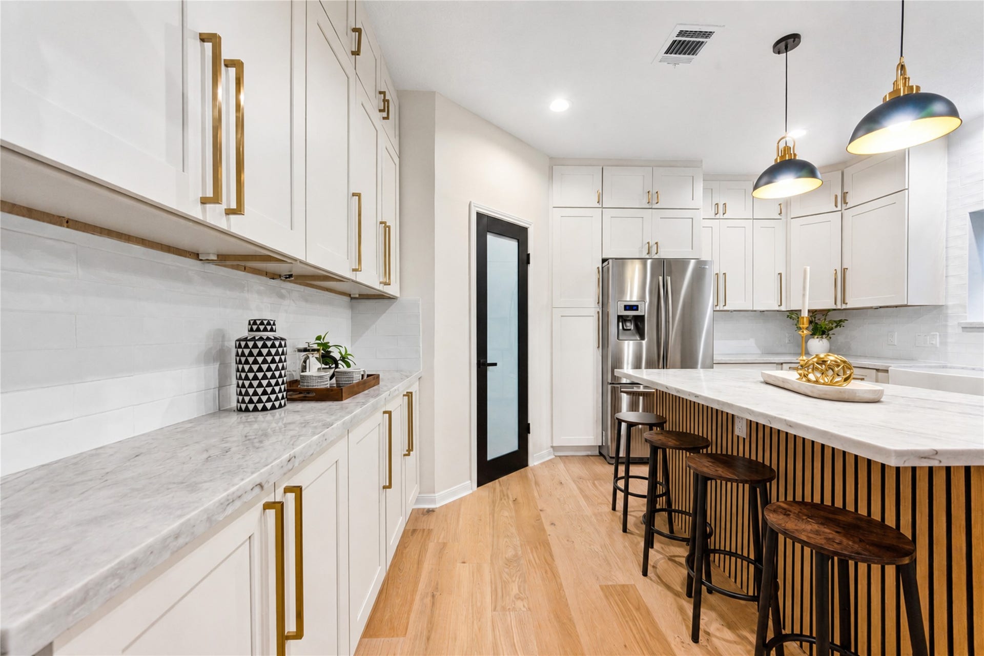 A closer view of the redesigned kitchen showcases the expansive quartzite countertops, generous island seating and abundant cabinetrycreating a stylish gathering place for morning coffee, casual meals, homework at the counter or catching up with friends while dinner is prepared.