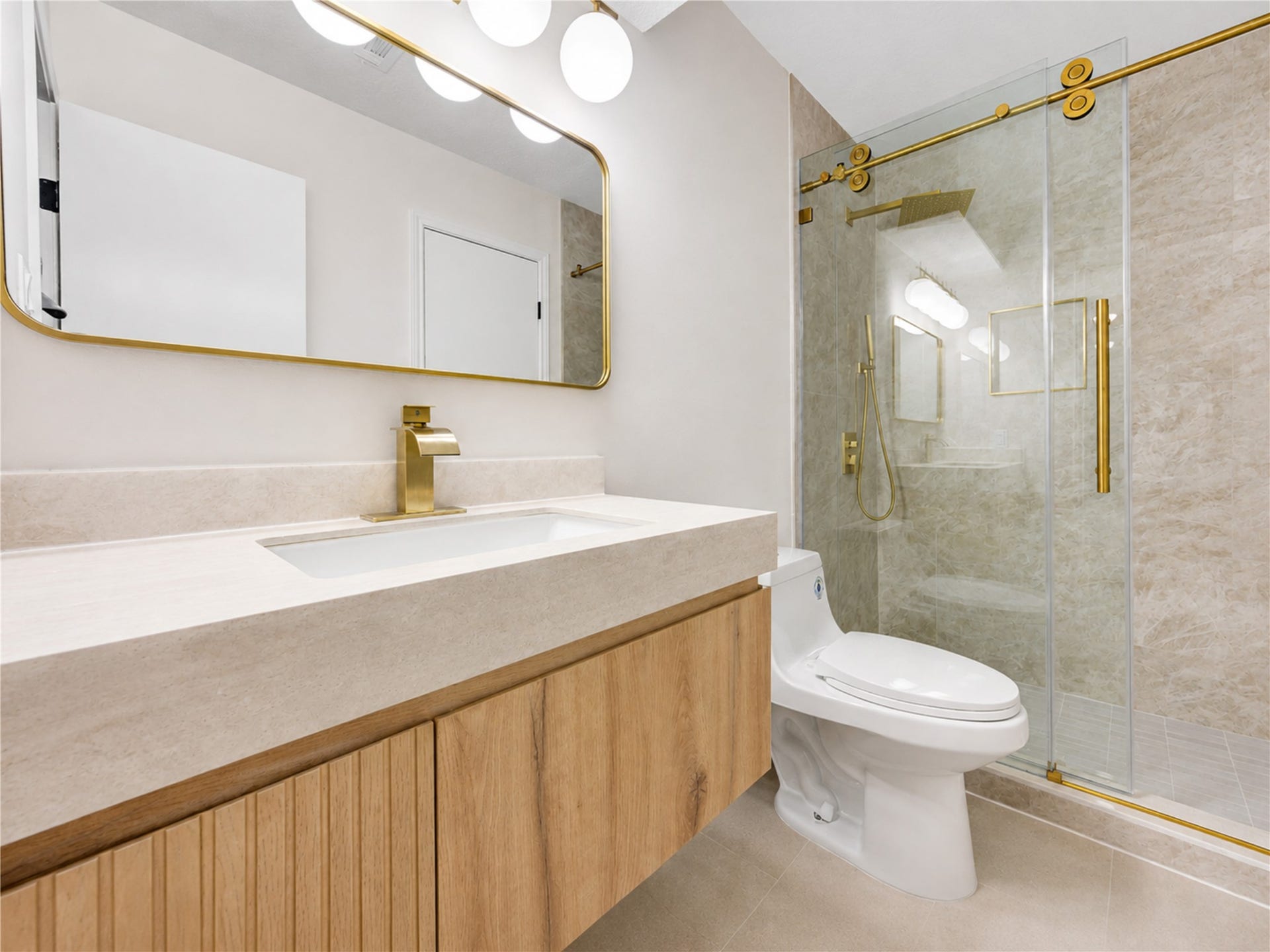 Updated ensuite bath offers a stylish private retreat with a modern vanity, sleek finishes and a spacious walk-in shower with frameless glass and striking gold accentsgiving family members or overnight guests the comfort and convenience of their own beautifully finished space.
