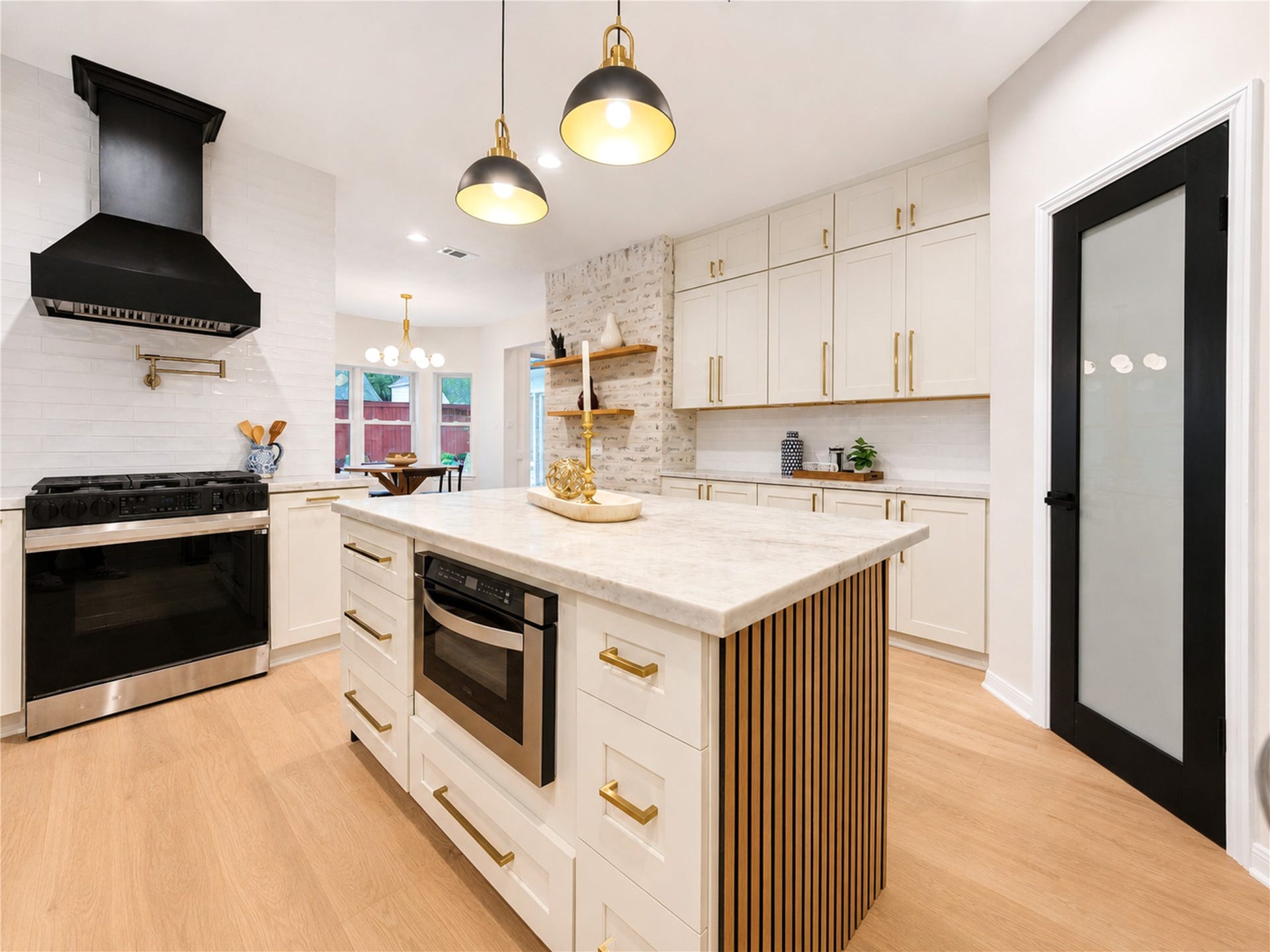 Designed for both everyday living and effortless entertaining, the beautifully renovated kitchen features a gas range with statement vent hood, convenient drawer microwave, quartzite countertops and a generous center island. From morning coffee and weeknight dinners to preparing a feast while guests gather around the island, this stylish space makes the kitchen the true heart of the home.