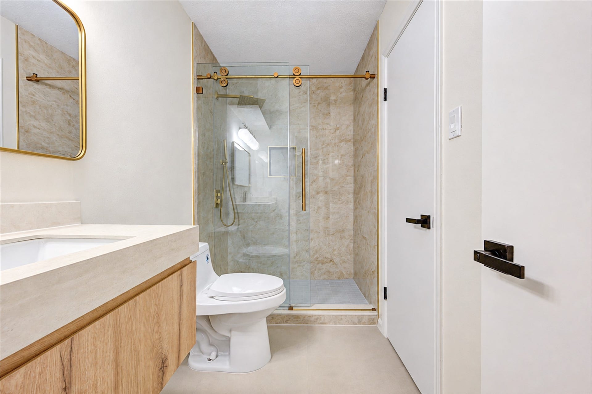 Second view of the updated ensuite bath highlights the spacious walk-in shower with frameless glass, beautiful tilework and striking gold fixturesbringing a polished, spa-inspired feel to this private upstairs retreat.