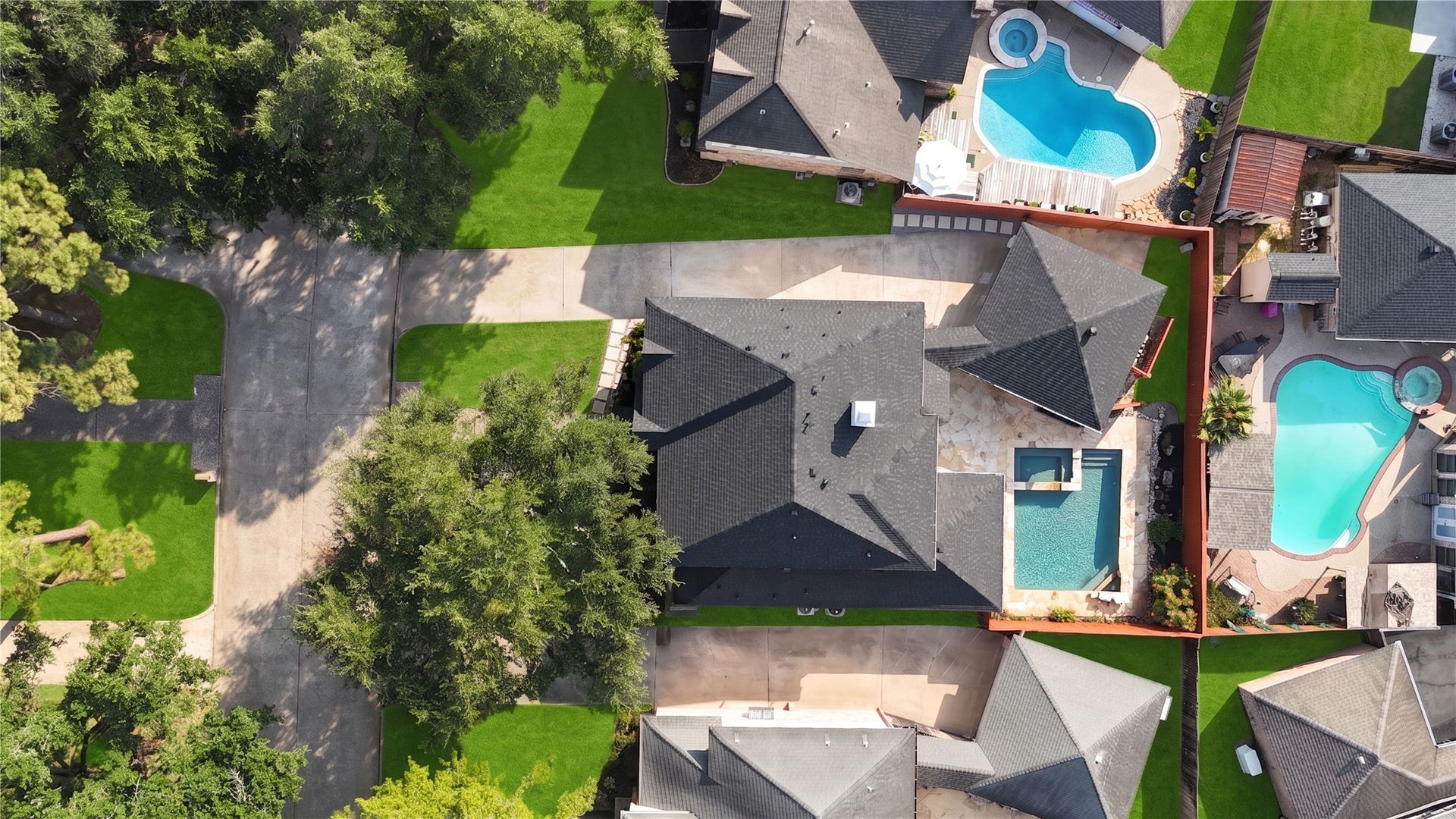 Aerial view showcasing the homes spacious setting, mature trees and private backyard retreat with a sparkling swimming poolperfect for relaxing, entertaining and enjoying sunny Texas days.