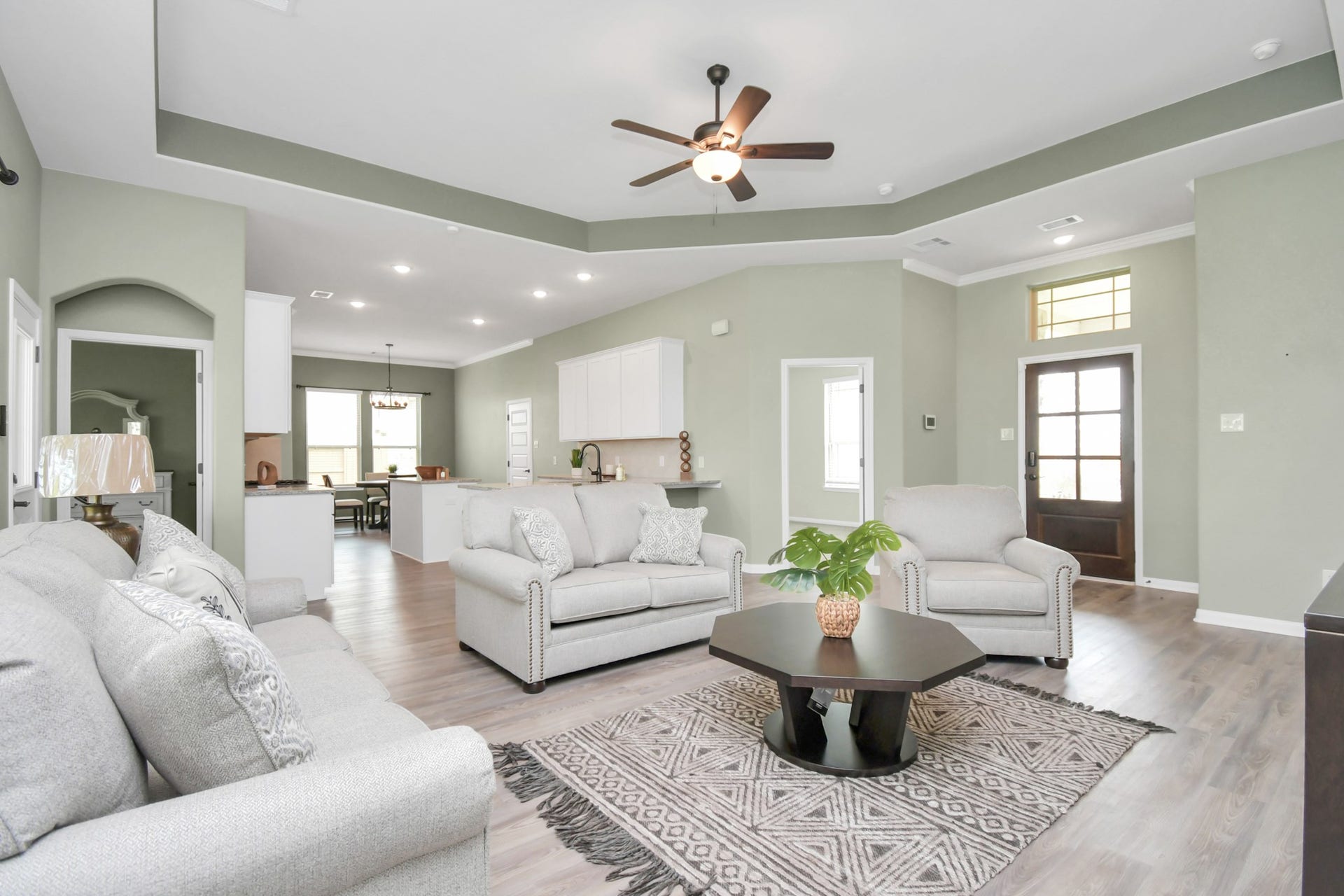 395 Hunter Ranch Way, Dayton, TX 77535 Spacious living room with tray ceiling and large windows overlooking the backyard