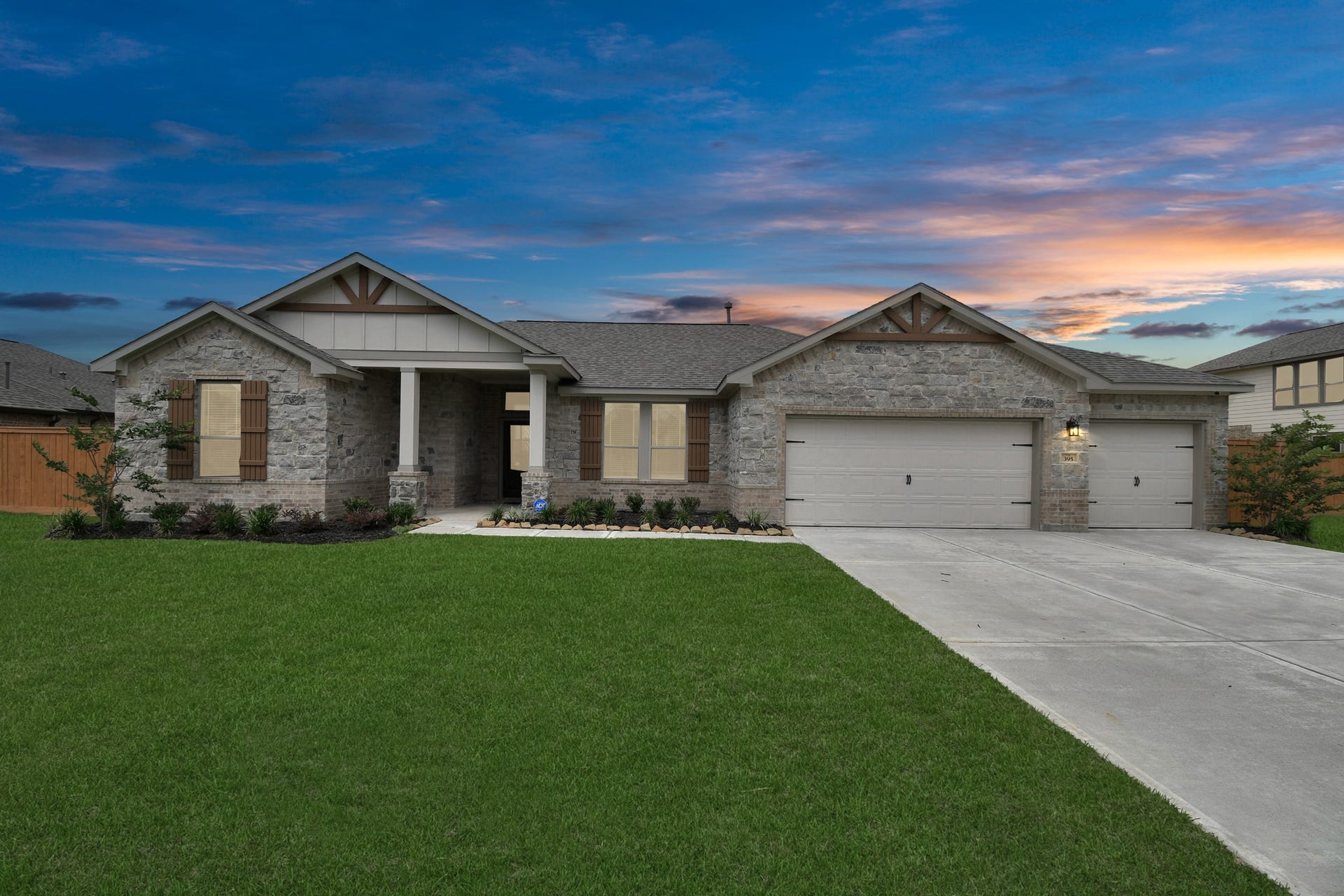 395 Hunter Ranch Way, Dayton, TX 77535 Welcoming front elevation with three car garage and spacious driveway