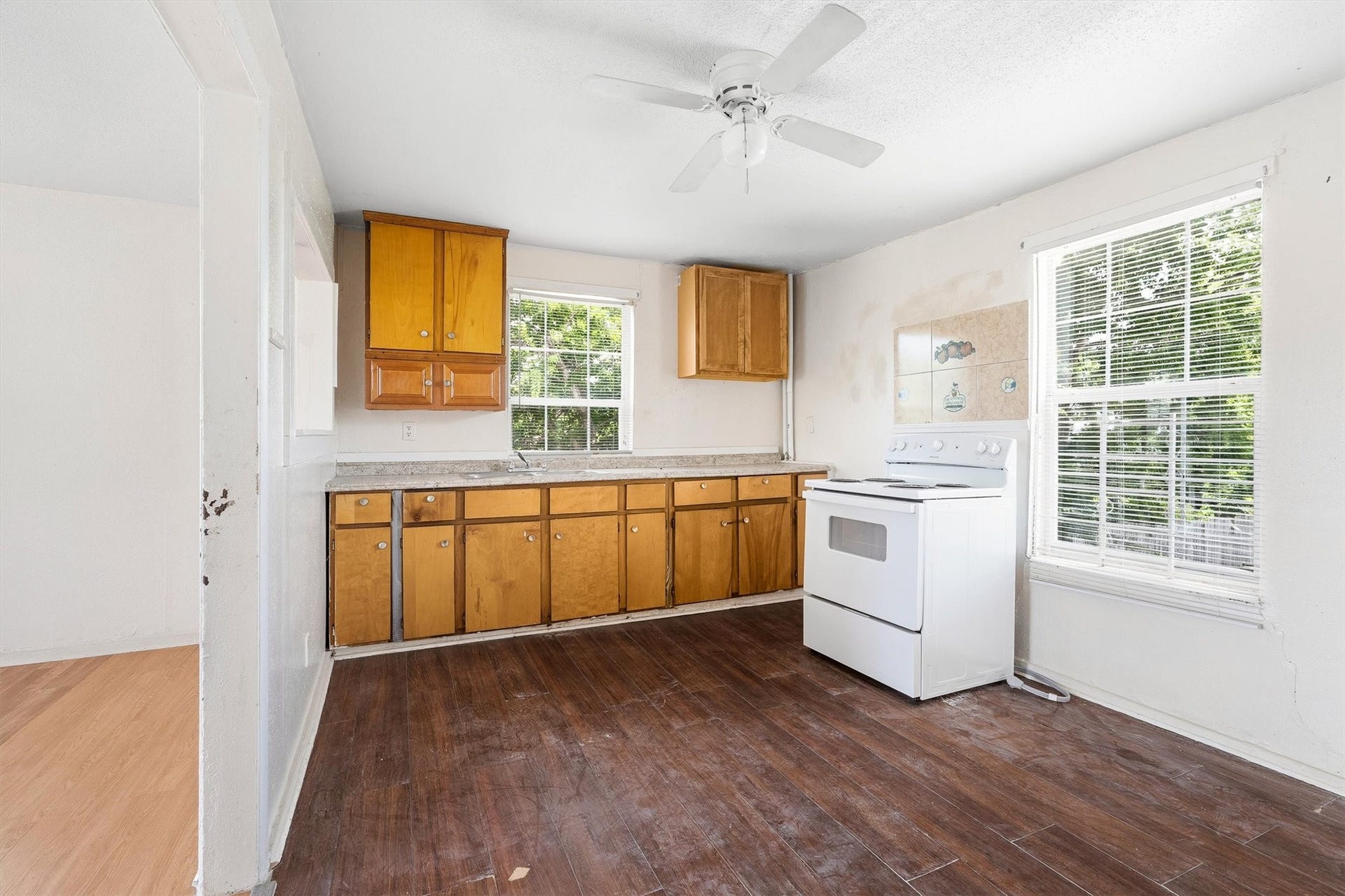 4233 Dupont Street, Houston, TX 77021 The first floor unit kitchen features stylish laminate flooring, a ceiling fan, and a large window with privacy blinds, creating a bright, comfortable, and functional space for everyday living.