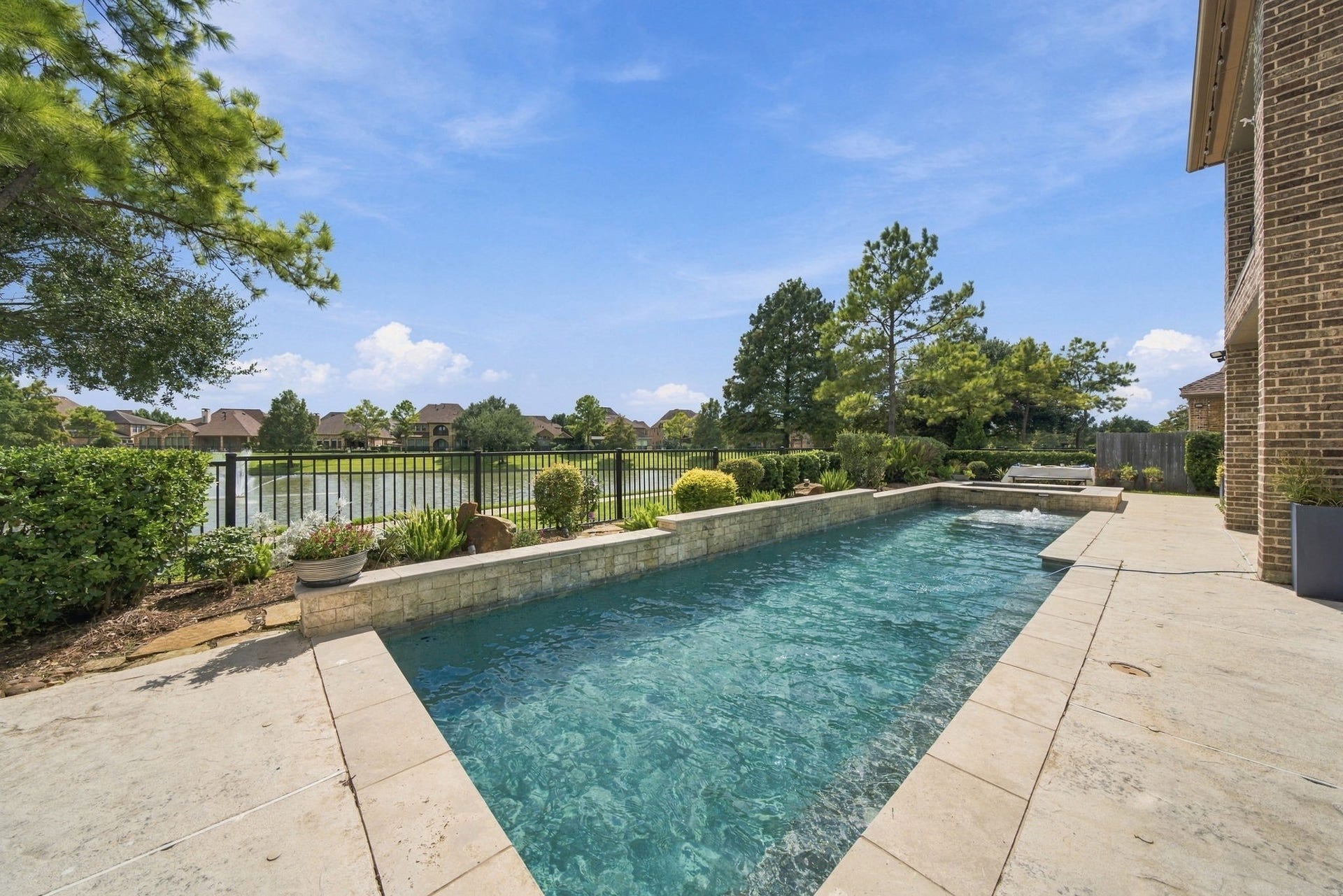 14423 Tivoli Drive, Houston, TX 77077 The pool and raised spa overlook the neighborhood lake, creating a scenic backdrop for outdoor living.